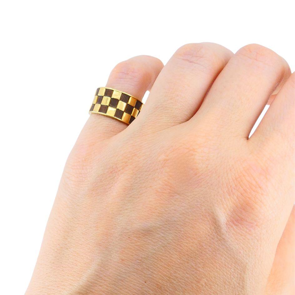 Questo anello vintage di Van Cleef & Arpels è stato creato negli anni '70.  Anni '70 a Parigi. L'anello è realizzato in oro giallo 18 carati e presenta un motivo a scacchiera alternato di quadrati d'oro lucido e intarsi in legno di palissandro