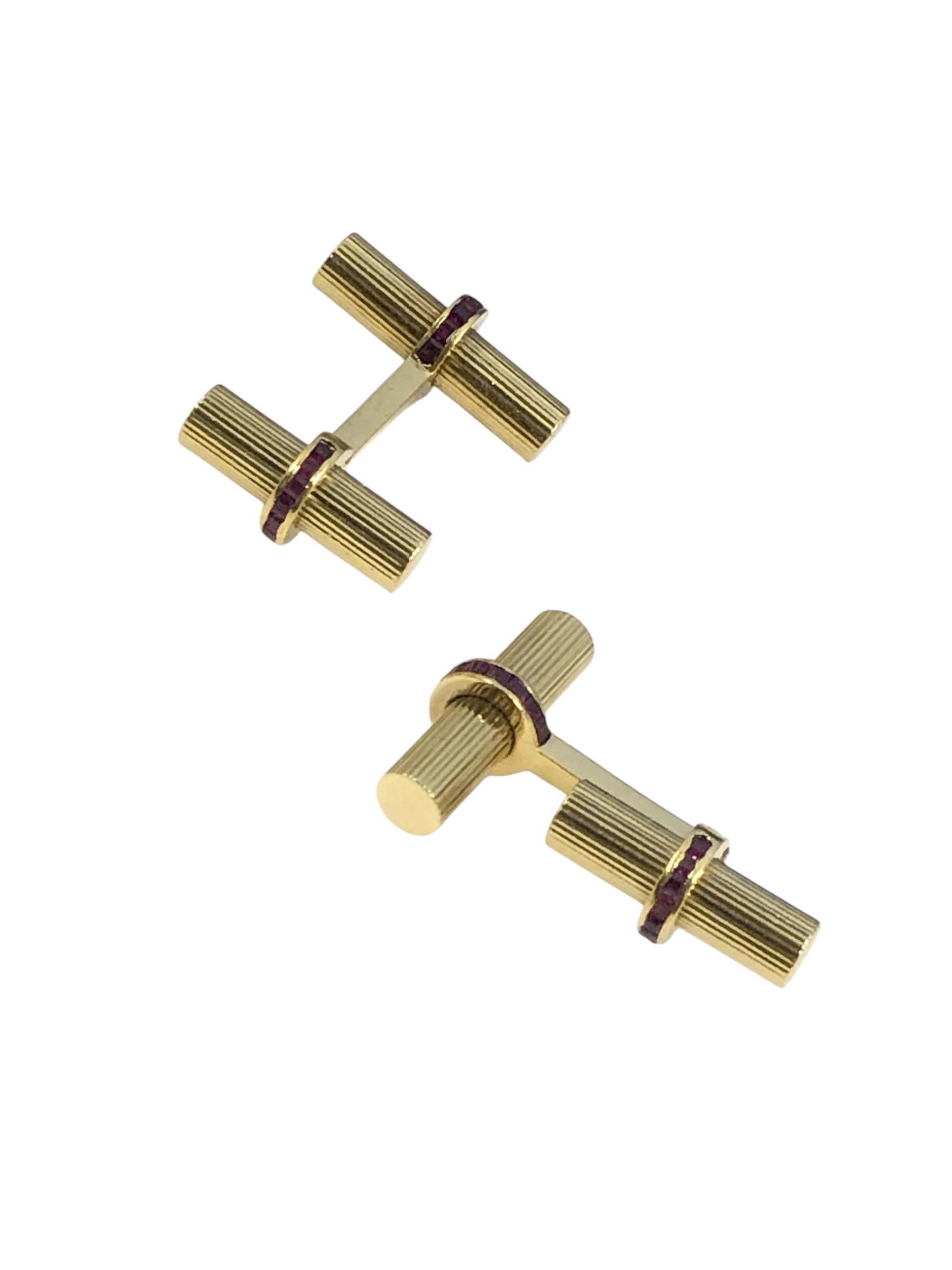 Circa 1980 Van Cleef & Arpels 18k Yellow Gold Cufflinks, having a Ribbed Bar design, the smaller portion is hinged for easy self on and off, the center sections are set with stepped cut Rubies. Signed, numbered and in the original presentation box. 