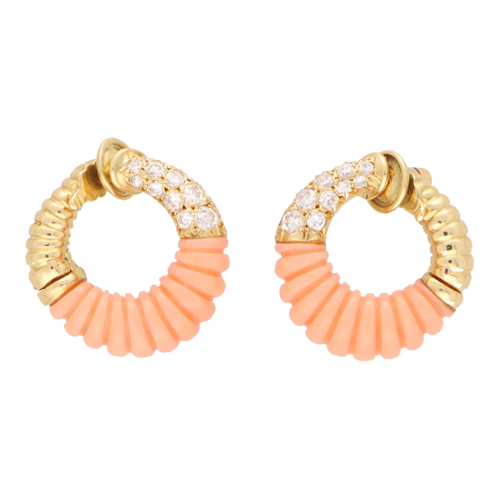 A highly unique vintage pair of Van Cleef & Arpels coral and diamond clip on hoop earrings set in 18k yellow gold.

These beautiful hoops are composed in a graduated circular motif and set to the centre with a carved pinkish-orange piece of coral.