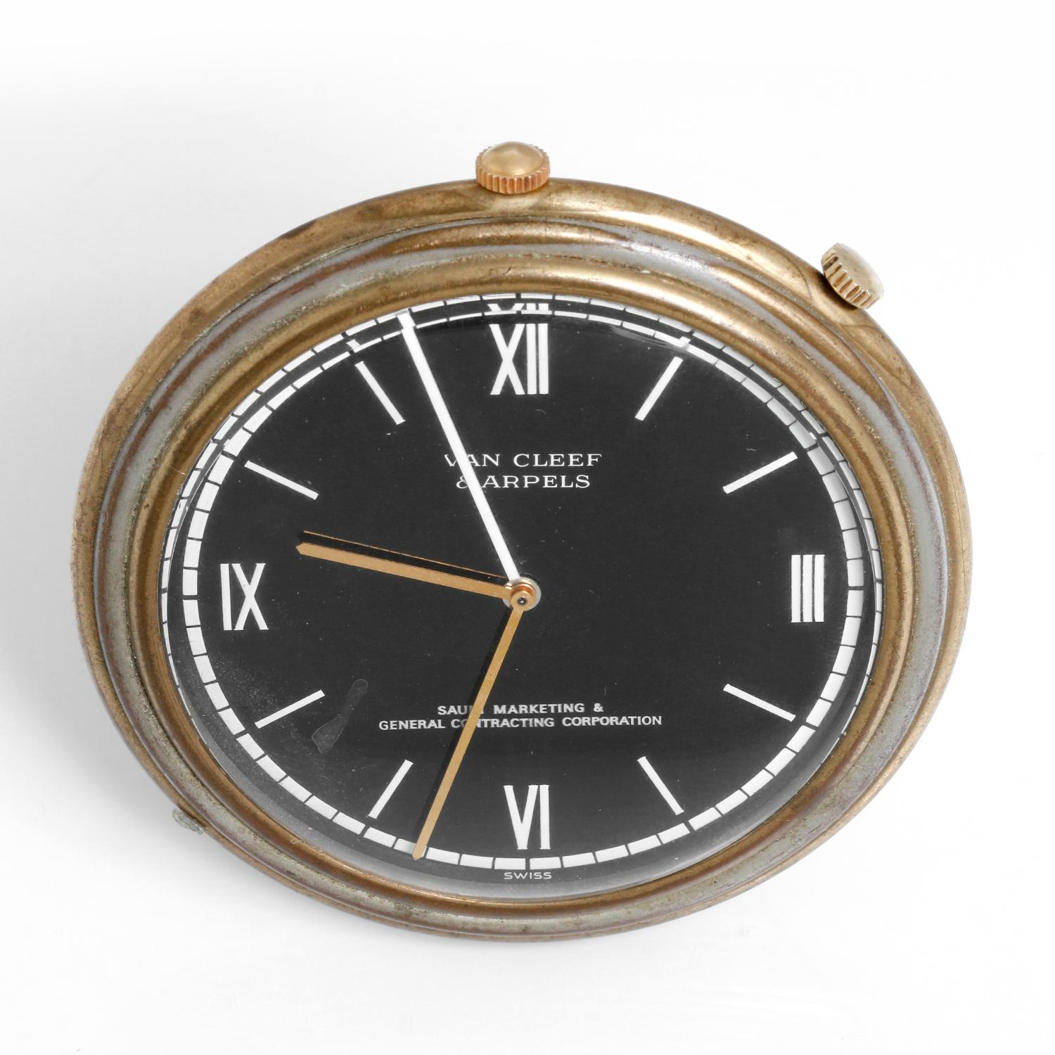 Vintage Van Cleef & Arpels Desktop Alarm Clock - Manual winding; movement by Gerald Genta. Brass case ( 69 mm ). Black dial with white roman numerals signed Saudi Marketing & General Contracting Corporation. Pre-owned with custom pouch . 
