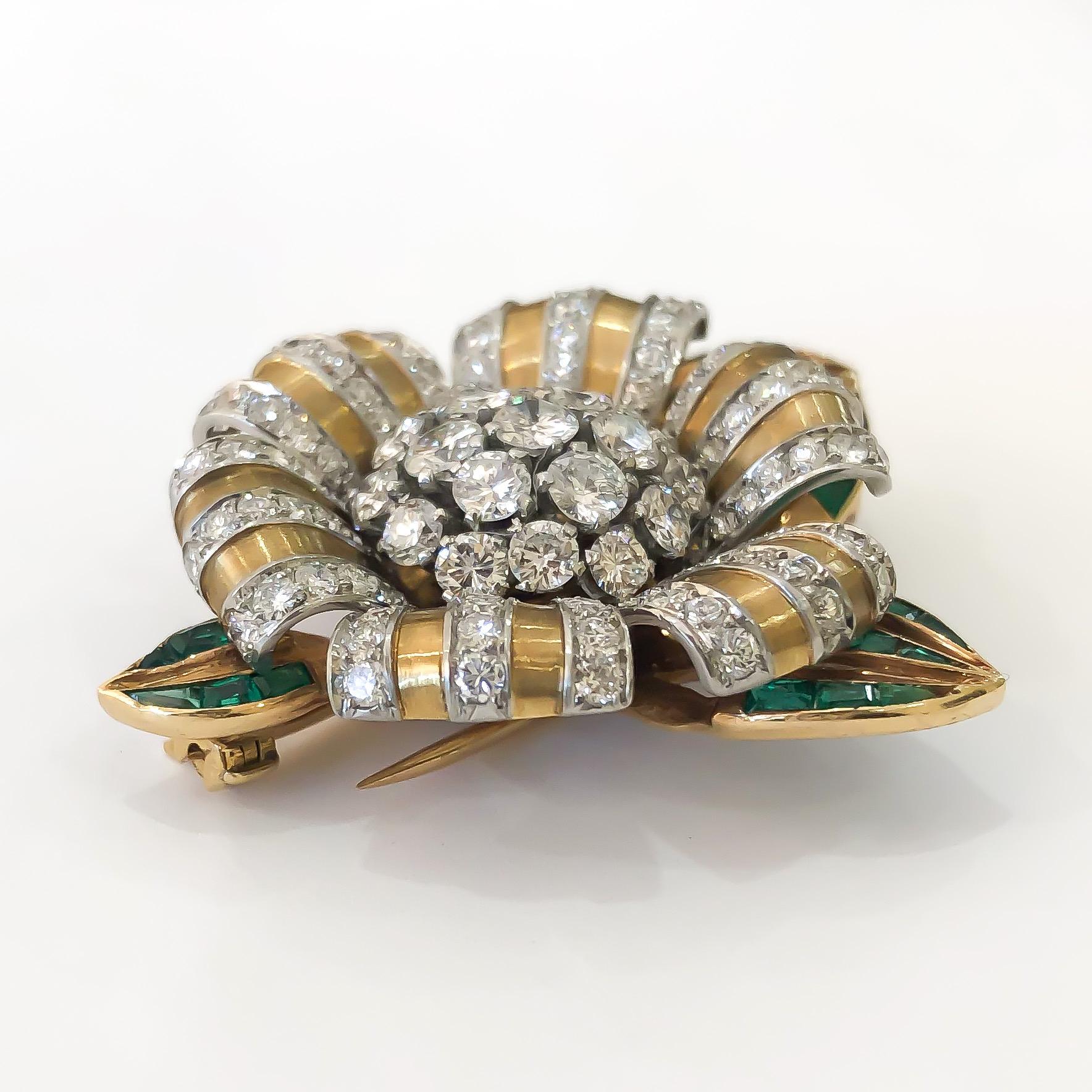 Beautiful vintage estate brooch by designer Van Cleef & Arpels. Crafted from premium 18 karat yellow gold and Platinum, and set with fine quality round brilliant cut diamonds and intense natural emeralds. The brooch is a flower ribbon motif