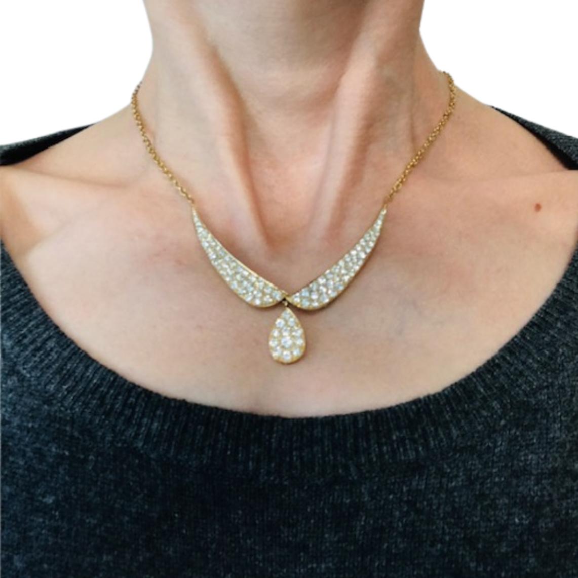 Questa collana vintage di Van Cleef & Arpels è finemente realizzata in oro giallo 18 carati e presenta un elegante design di diamanti. u2028L'elemento centrale comprende due sezioni curve che si incontrano al centro, dove un pendente a forma di