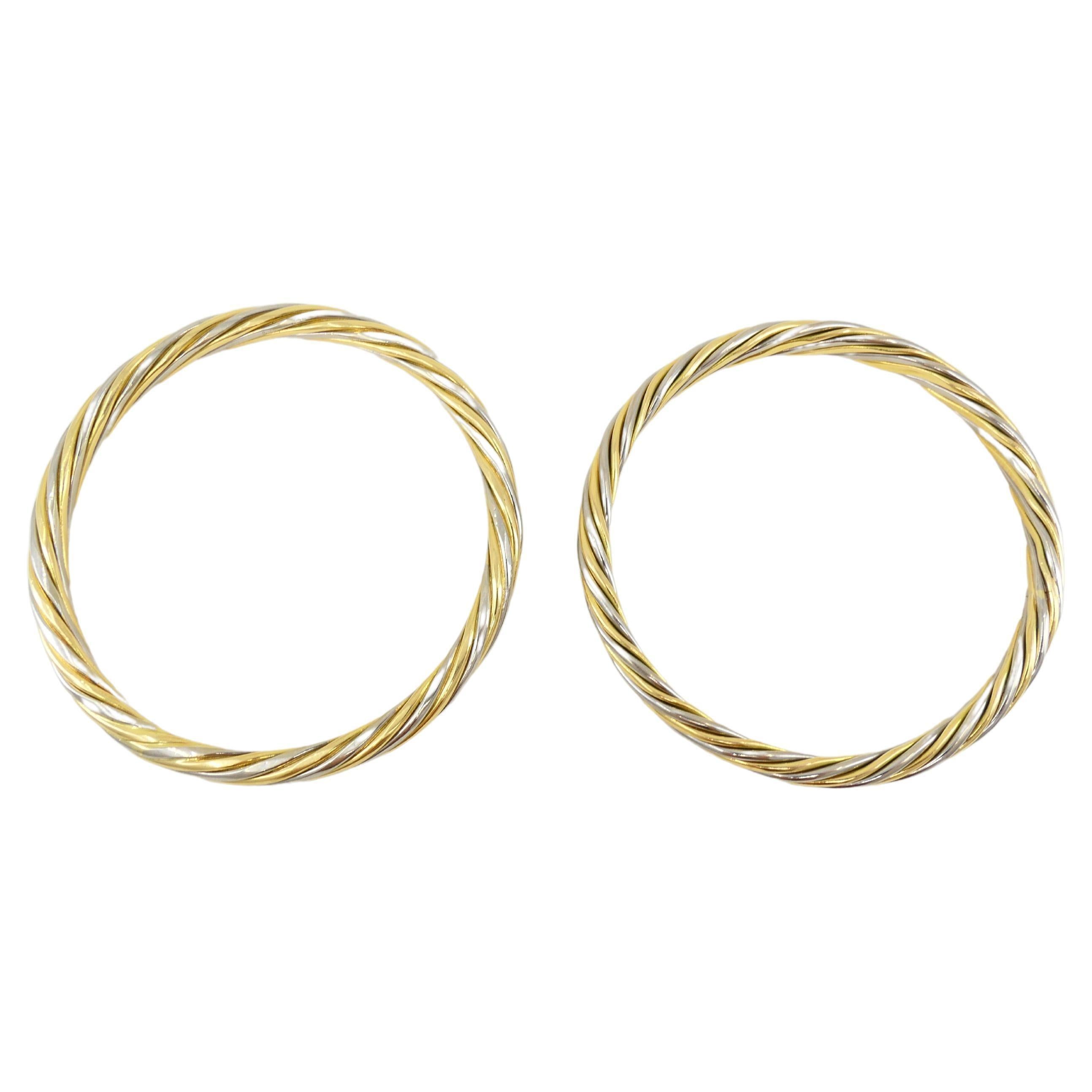 A gorgeous pair of vintage Van Cleef & Arpels bangle bracelets made of 18k white and yellow gold. It's designed as alternating white and yellow gold wires swirling around the bracelet. One bracelet is slightly bigger than another (7