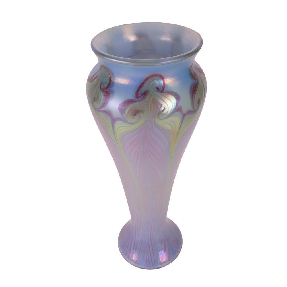 Diese schöne Vase aus Vandermark-Kunstglas von Merritt präsentiert sich in einer schönen Form. Die Vase ist mit einem geflochtenen und Hakenfedermuster verziert. Die Hauptfarbe dieser Vase ist ein schillerndes Pastellblau an der Schulter und Violett