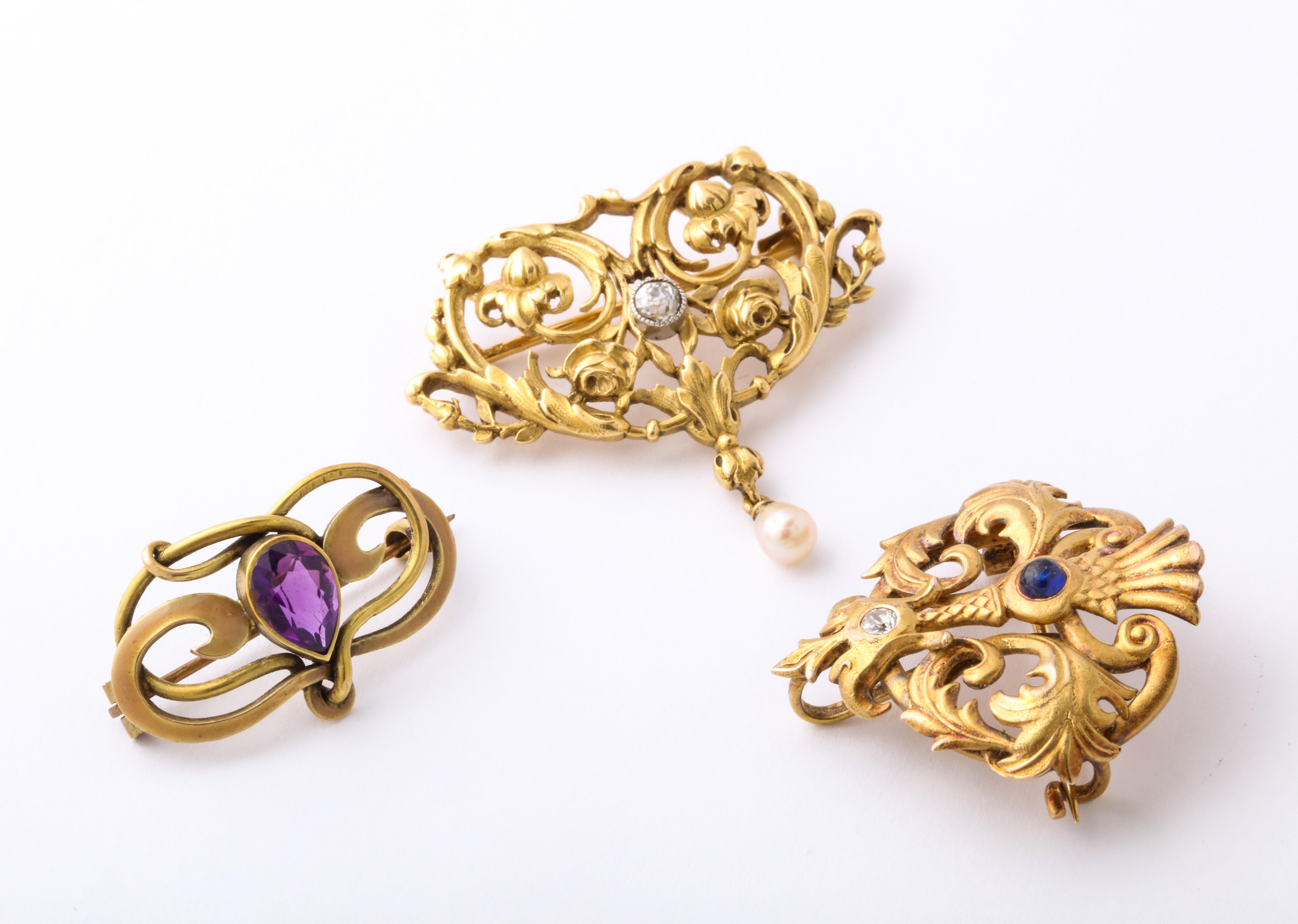 Three various brooches, all with the finest gold work from the early 1900's, are from the far right, a Rikers brooch in 14 Kt with a sapphire and diamond. Rikers is a highly reputed jewelry firm from Newark that made jewelry when the American