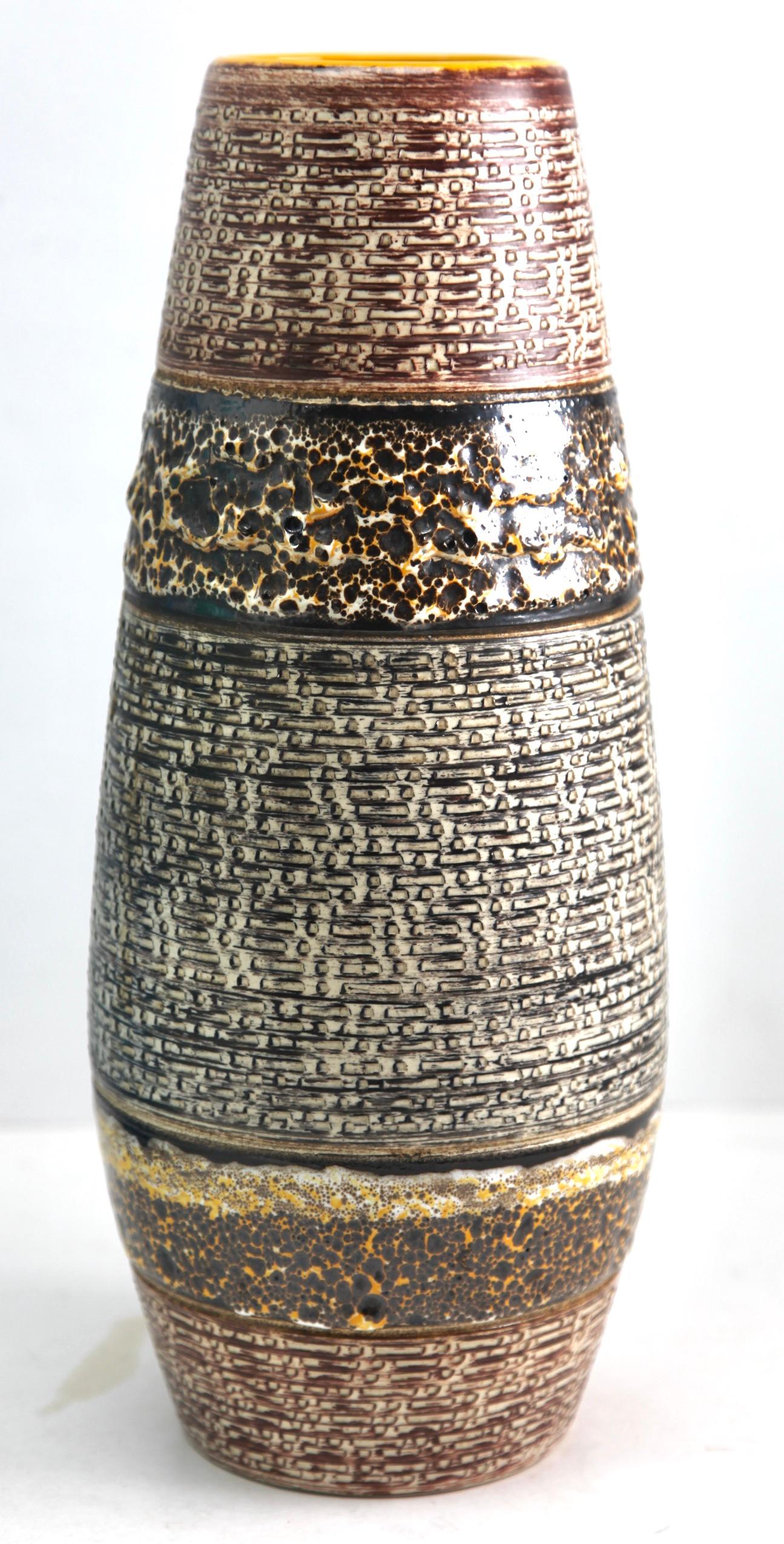 Ce vase vintage original a été produit dans les années 1970 en Allemagne. Il est fabriqué en poterie céramique.
Le fond est marqué du numéro de série du vase 136-40 Handarbeit.
Un design direct et minimaliste de l'ère du design des années 1960.