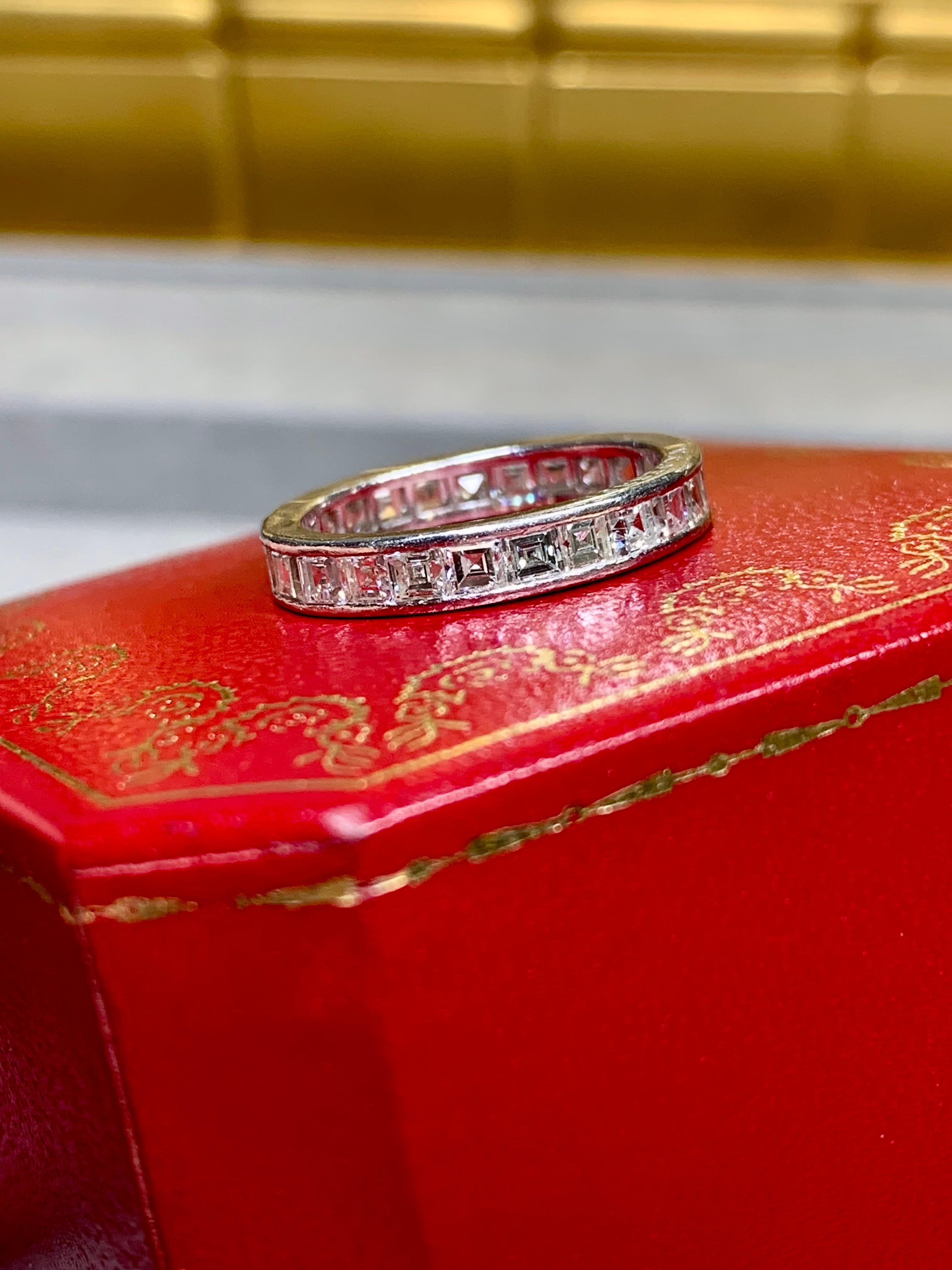 Una fascia eternità vintage realizzata in platino da Cartier in collaborazione con V.I.C.. Perren (Verger Fères). È stato incastonato con circa 3,75 carati di diamanti taglio quadrato/carro di colore F-G e purezza Vs1+. Questa fascia è accompagnata