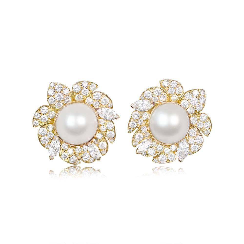 A vintage pair of Van Cleef and Arpels earrings showcasing natural saltwater button pearls weighing 12.04 and 13.08 carats. These pearls exhibit beautiful color and high luster, surrounded by petals set with round brilliant and marquise-cut
