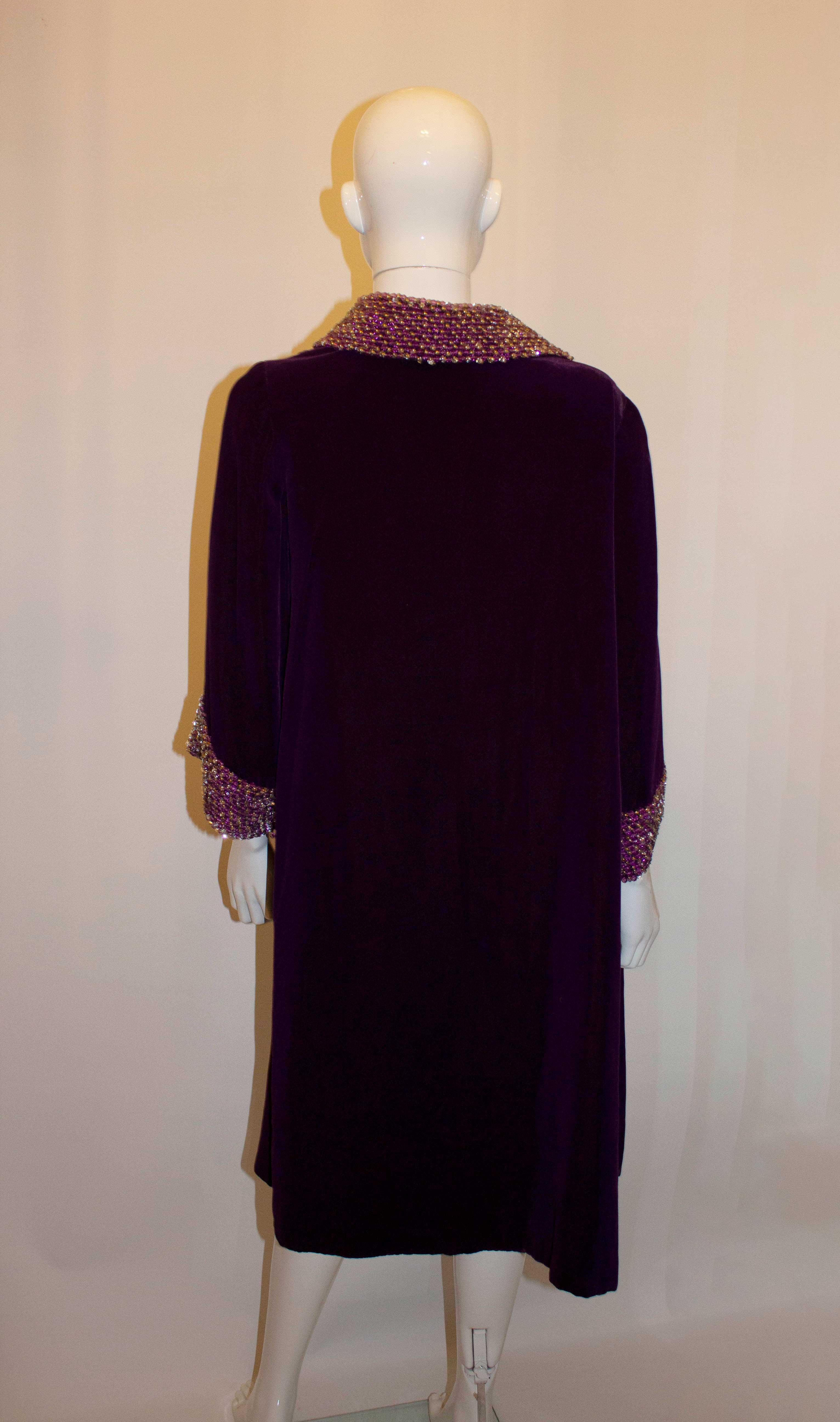 A stunning vintage evening coat in a purple velvet, with decorative collar and cuffs. The coat is fully lined. Measurments Bust 35'', length 39'' plus a 3'' hem. 