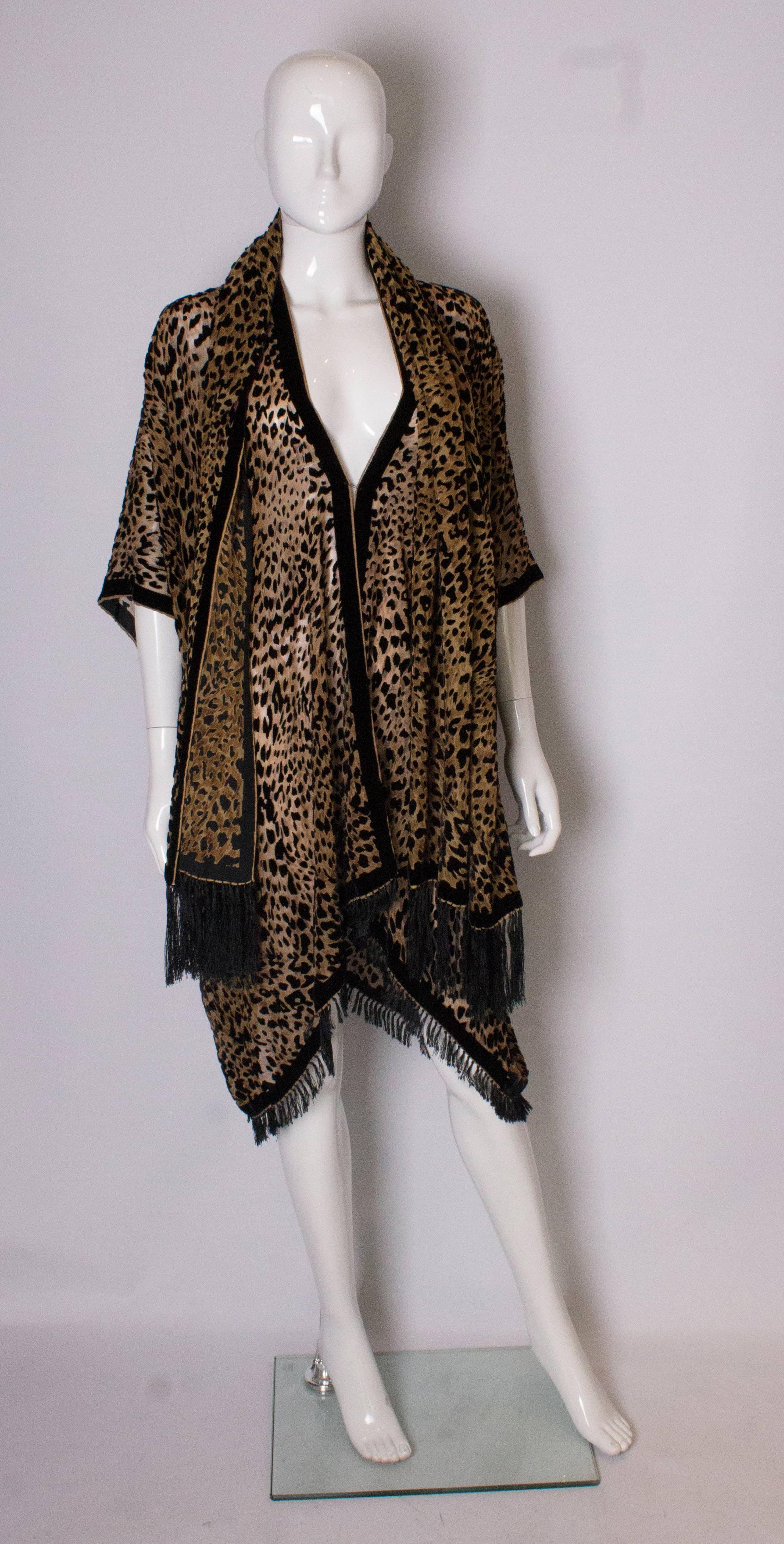 A great devoree velvet jacket and scarf in an animal print design. The jacket has a velvet trim at the front and cuffs, and fringing at the hem. It is meant to be worn loose and can fit a bust up to 48'', length 38'