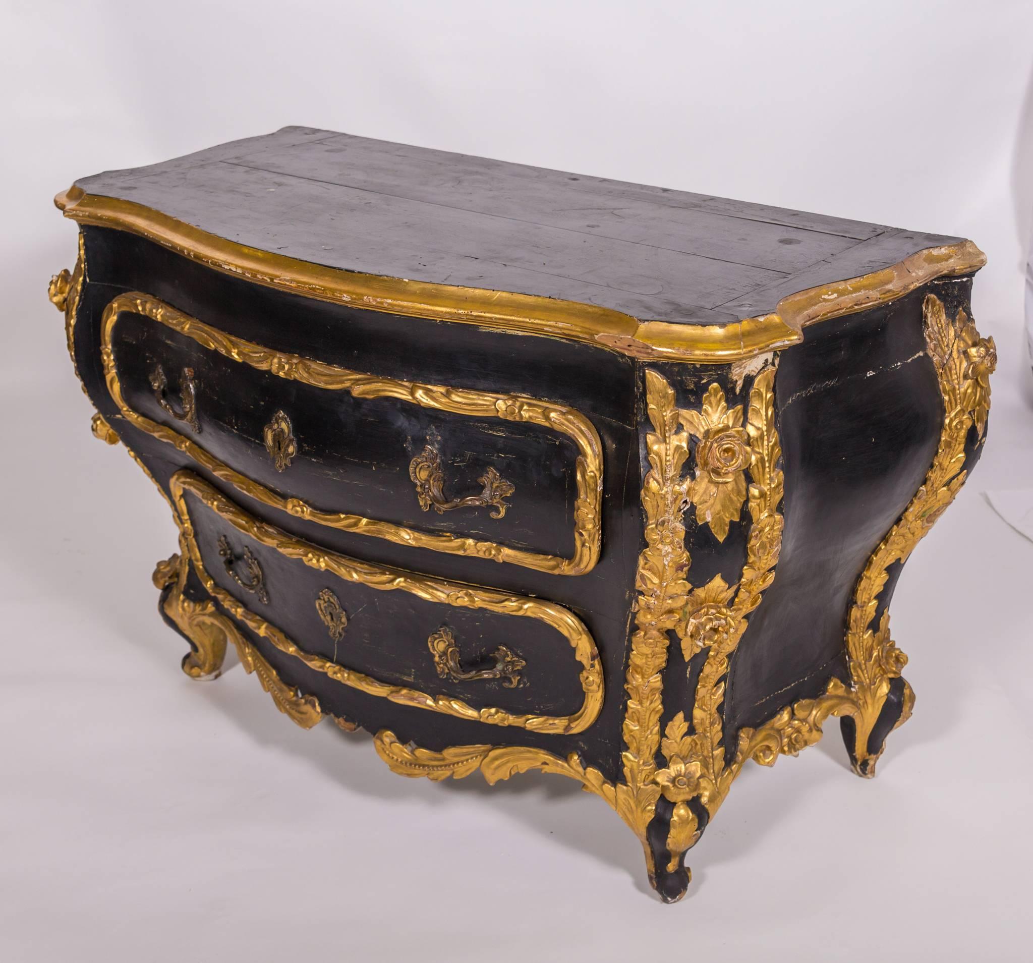 This Vintage Italian painted chest with gilded detail is a true statement piece. The
contrasting black-painted body and gilded carved details on this vintage Italian chest is instantly striking. There is plenty of storage for use in a bedroom or