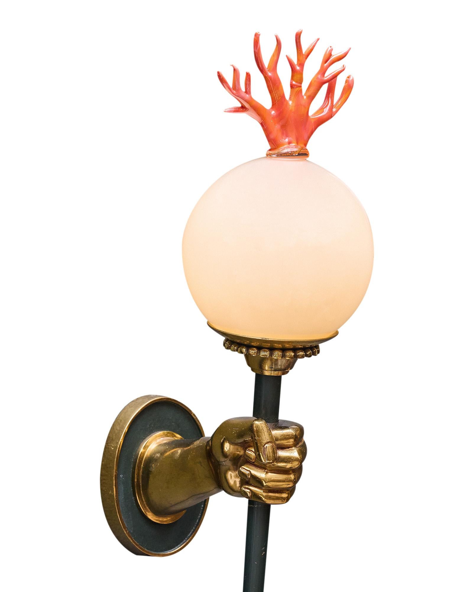 Pair of sconces from Venice, Italy with an Empire style structure of hands holding a torch. The structures are made of solid brass. At the top is a hand-blown Murano glass orb with a glass coral finial. They have been newly wired to fit US standards.