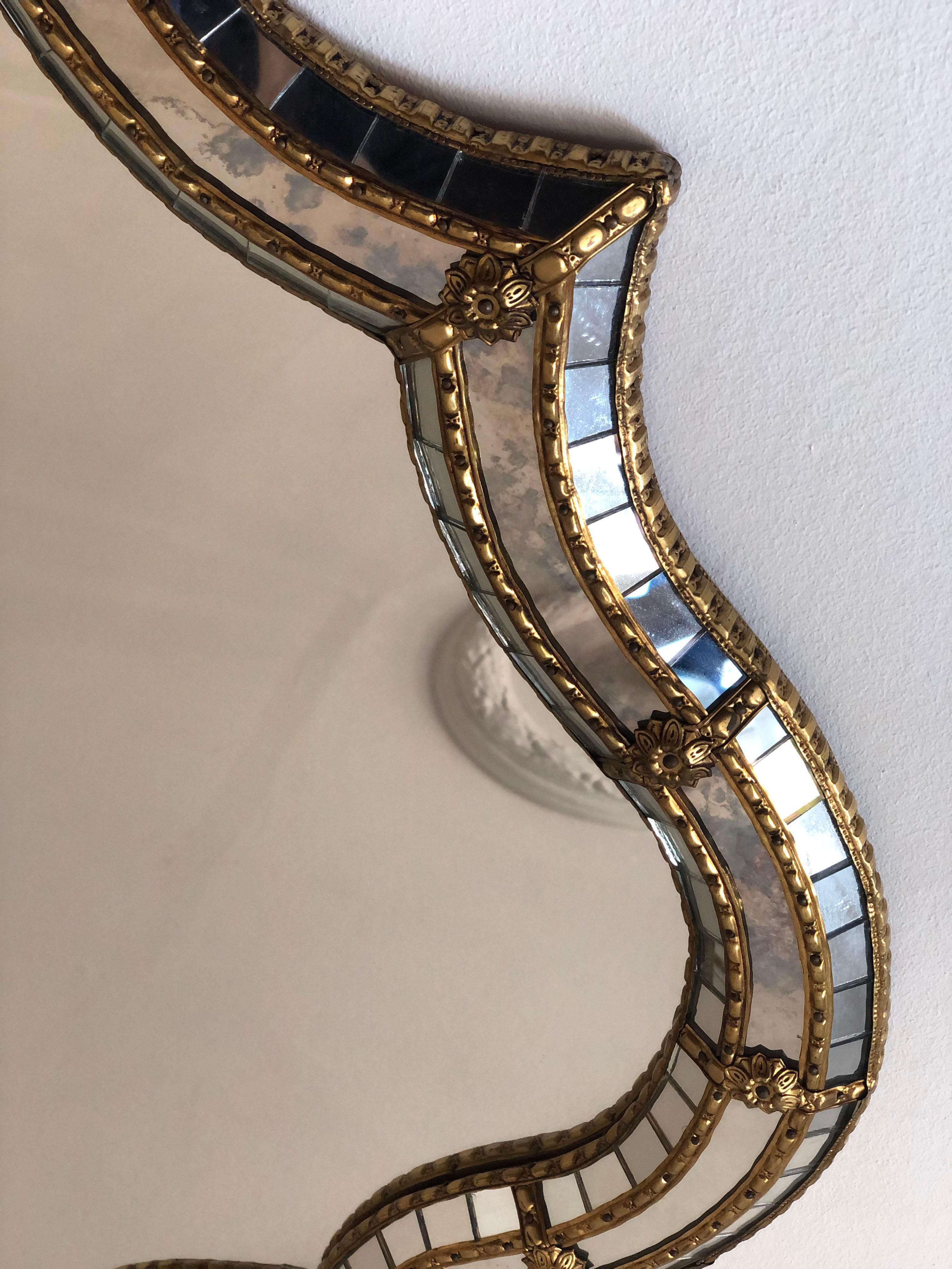 Este espejo veneciano vintage de los años 90 muestra una elegante silueta ondulada y una superficie de cristal biselado que eleva al instante cualquier interior.
El marco de cristal artesanal está ricamente detallado, con pequeños cristales a lo
