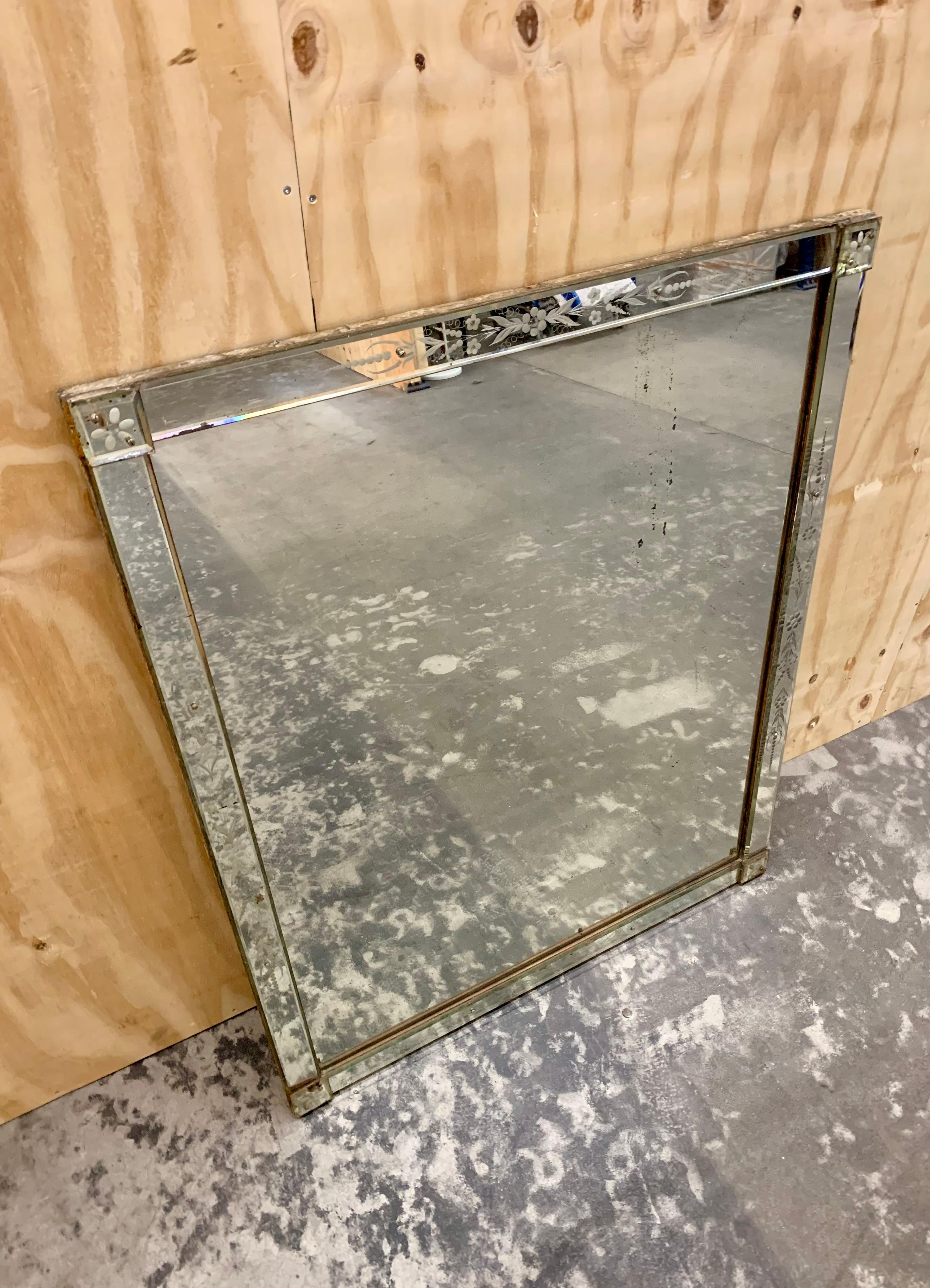 Grand miroir vénitien vintage avec des décorations gravées sur le cadre et avec le verre d'origine. Le miroir des années 1920-30 présente une belle patine d'âge et d'utilisation, mais il est intact et ne présente aucune entaille ou coupure.