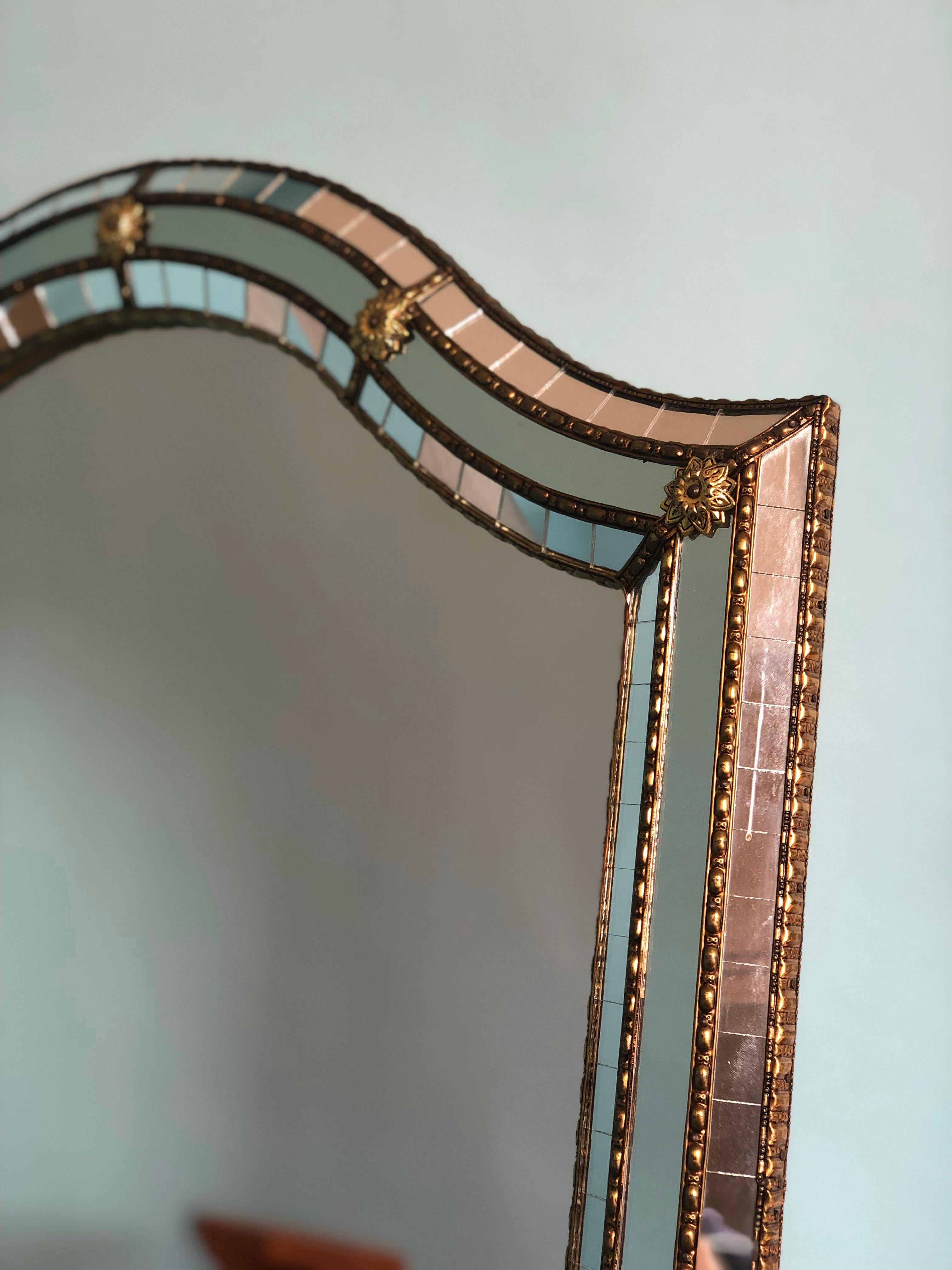 Beautiful Spanish mirror with a Venetian glass frame with a brass golden strip. The frame is made with small crystals both on the outside and inside, and larger ones in the center line. The brass strip holds the mirrors together.

Handmade mirror In