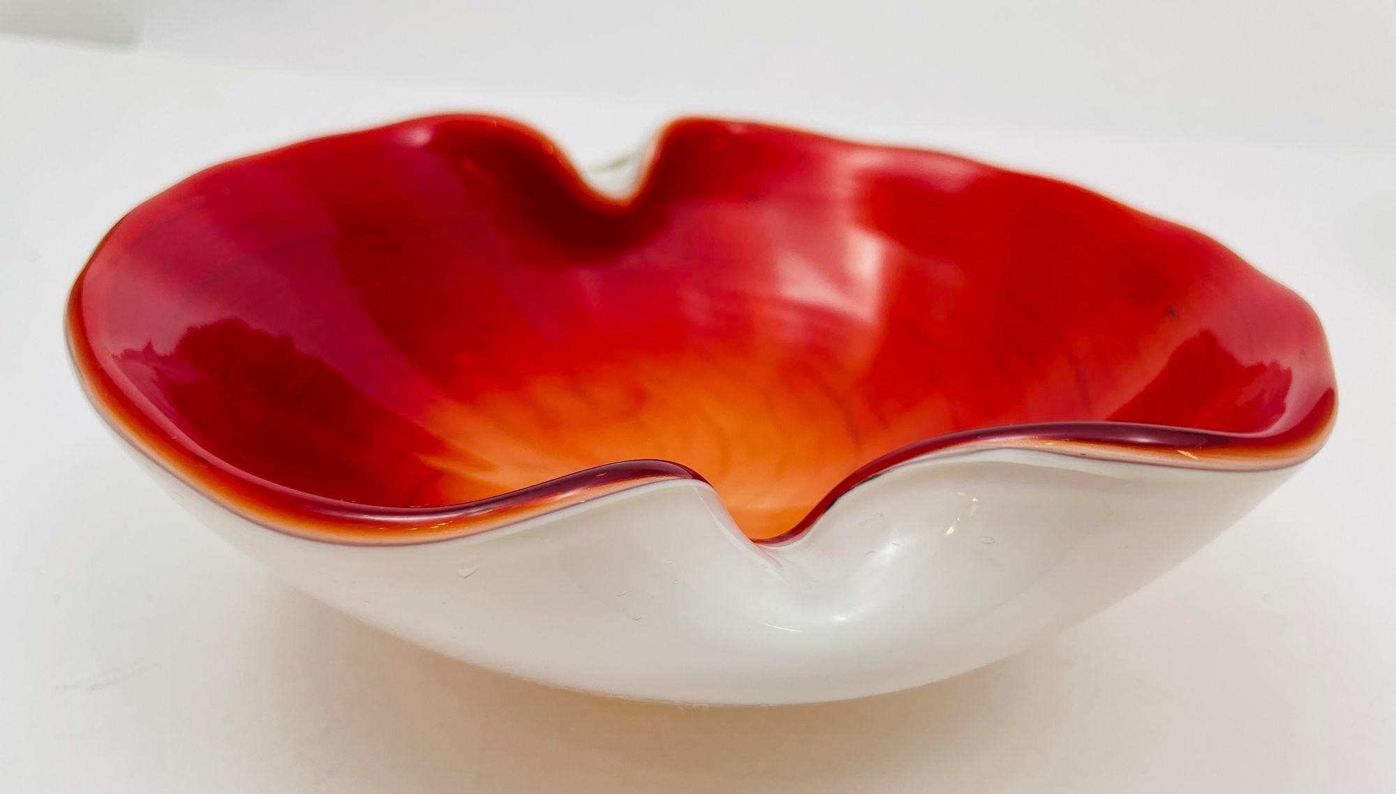 Gorgeous mid-20th century Italian Murano Venetian hand-blown art glass catchall dish, candy bowl or ashtray.
This sculptural piece features an organic open shape form in red with beautiful gold flecks decoration in the aventurine technique.
The bowl