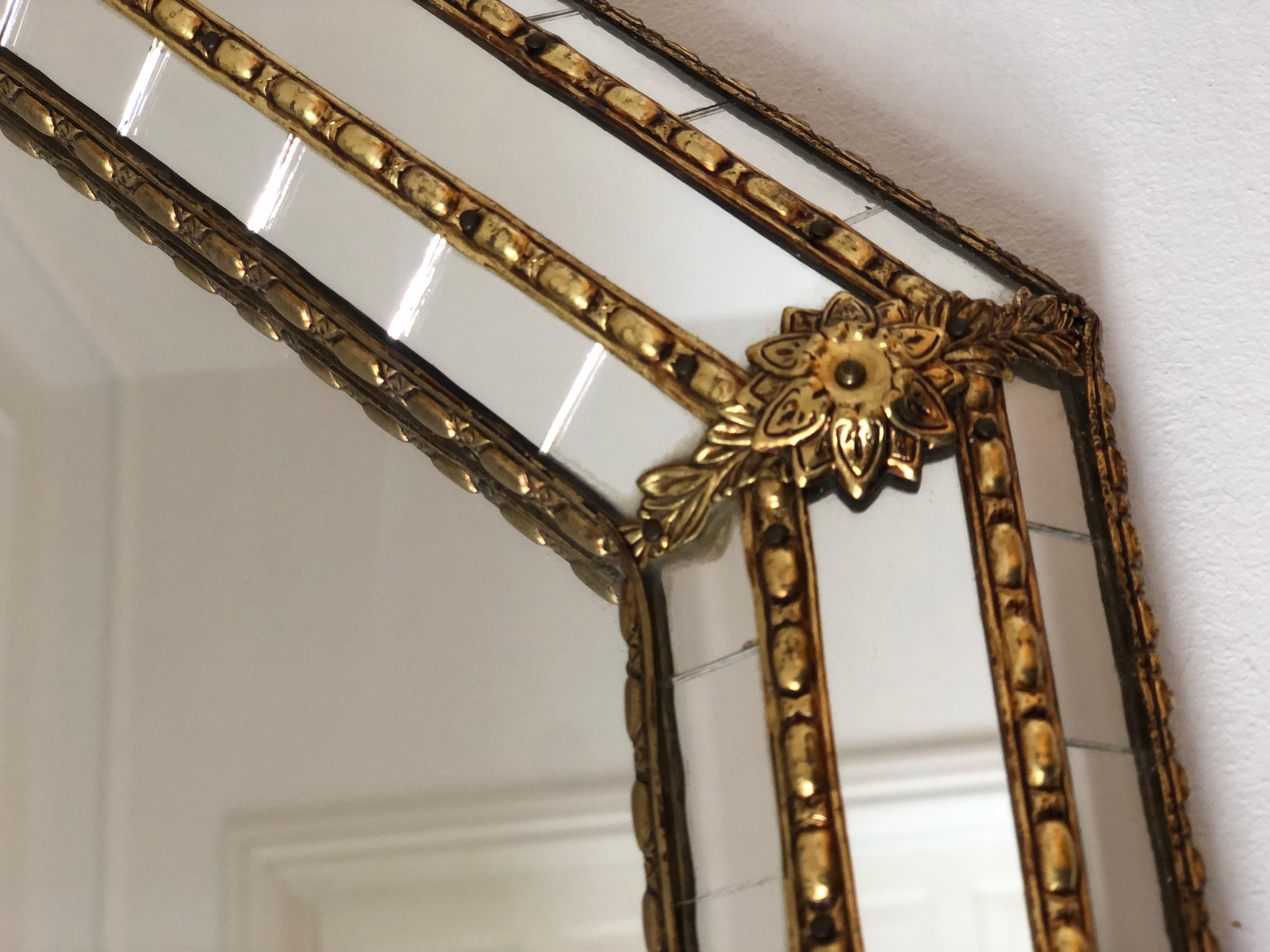 A Vintage Venetian octagon mirror in Spanish style, dating back to the 1990s.
The frame is beautifully hand-crafted and decorated with small crystals on the outer and inner edges, with larger crystals running along the center. The elegant brass
