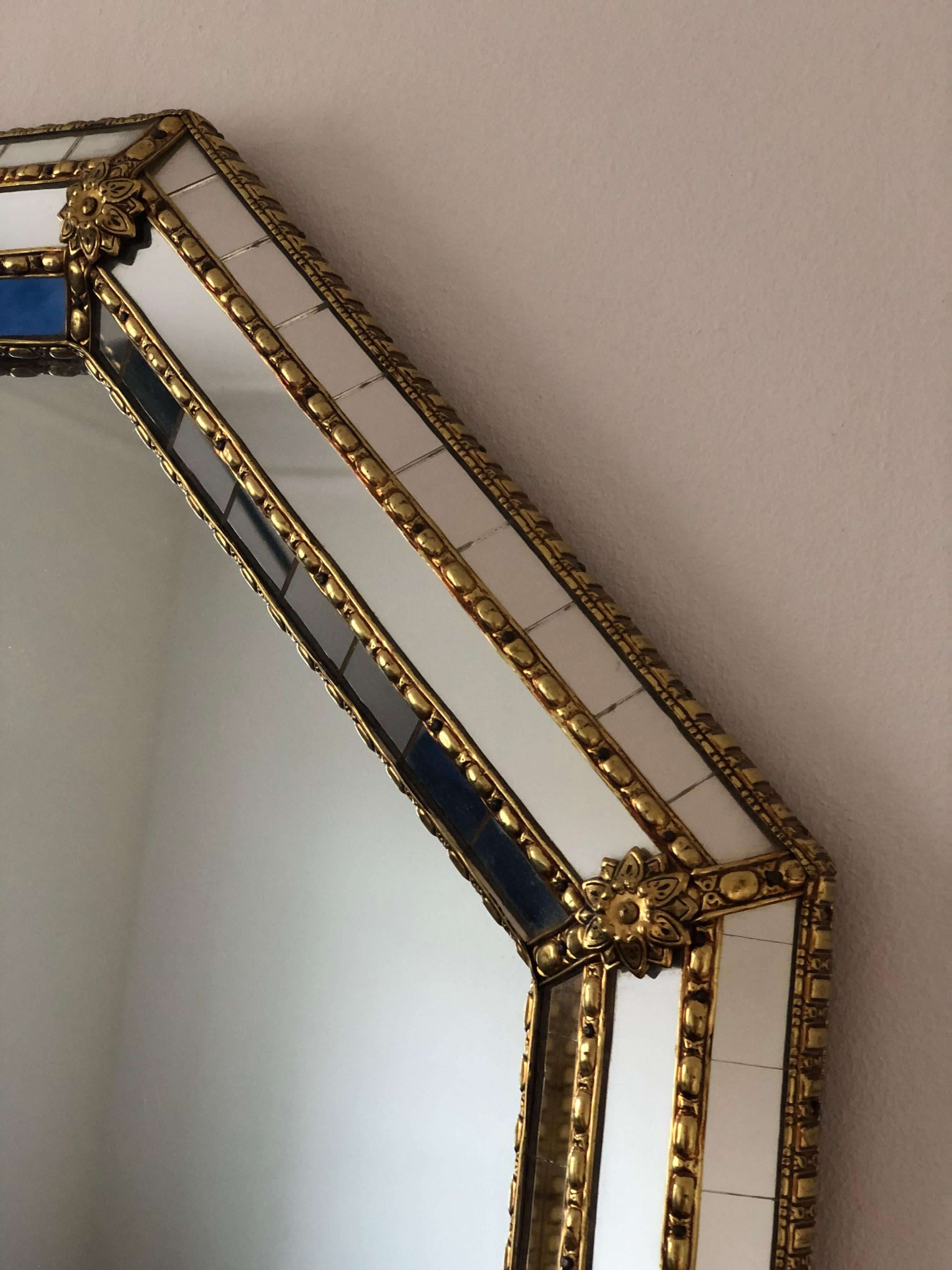A Vintage Venetian octagon mirror in Spanish style, dating back to the 1990s.
The frame is beautifully hand-crafted and decorated with small crystals on the outer and inner edges, with larger crystals running along the center. The elegant brass