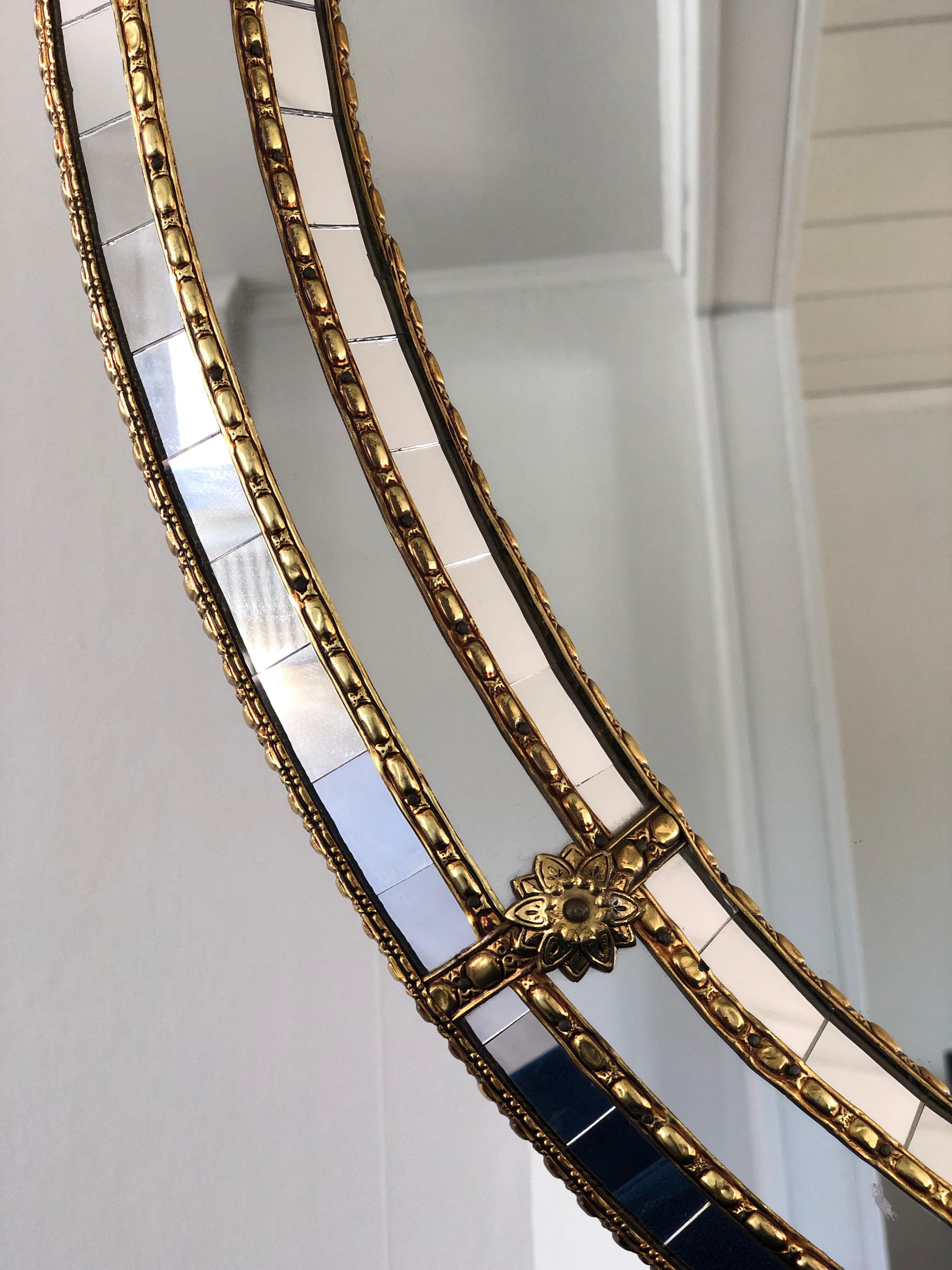 Magnifique miroir espagnol ovale avec un cadre en verre vénitien avec une bande dorée en laiton. Le cadre est composé de petits cristaux à l'extérieur et à l'intérieur, et de cristaux plus grands dans la ligne centrale. La bande de laiton maintient