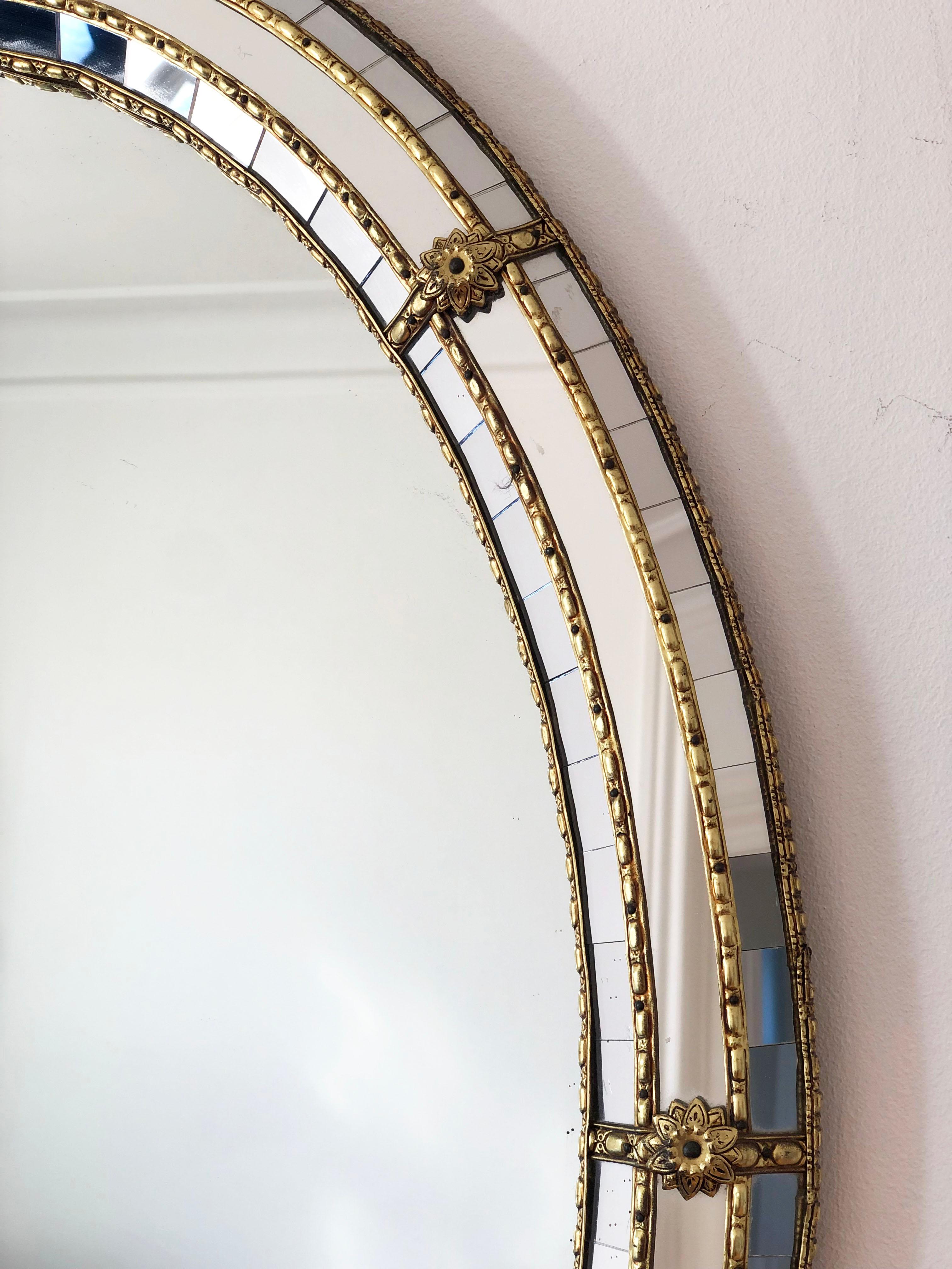 Grande specchio smussato veneziano vintage in stile spagnolo, risalente agli anni '90.
La cornice in vetro è splendidamente lavorata a mano e decorata con piccoli cristalli sui bordi esterni e interni, con cristalli più grandi che corrono lungo il