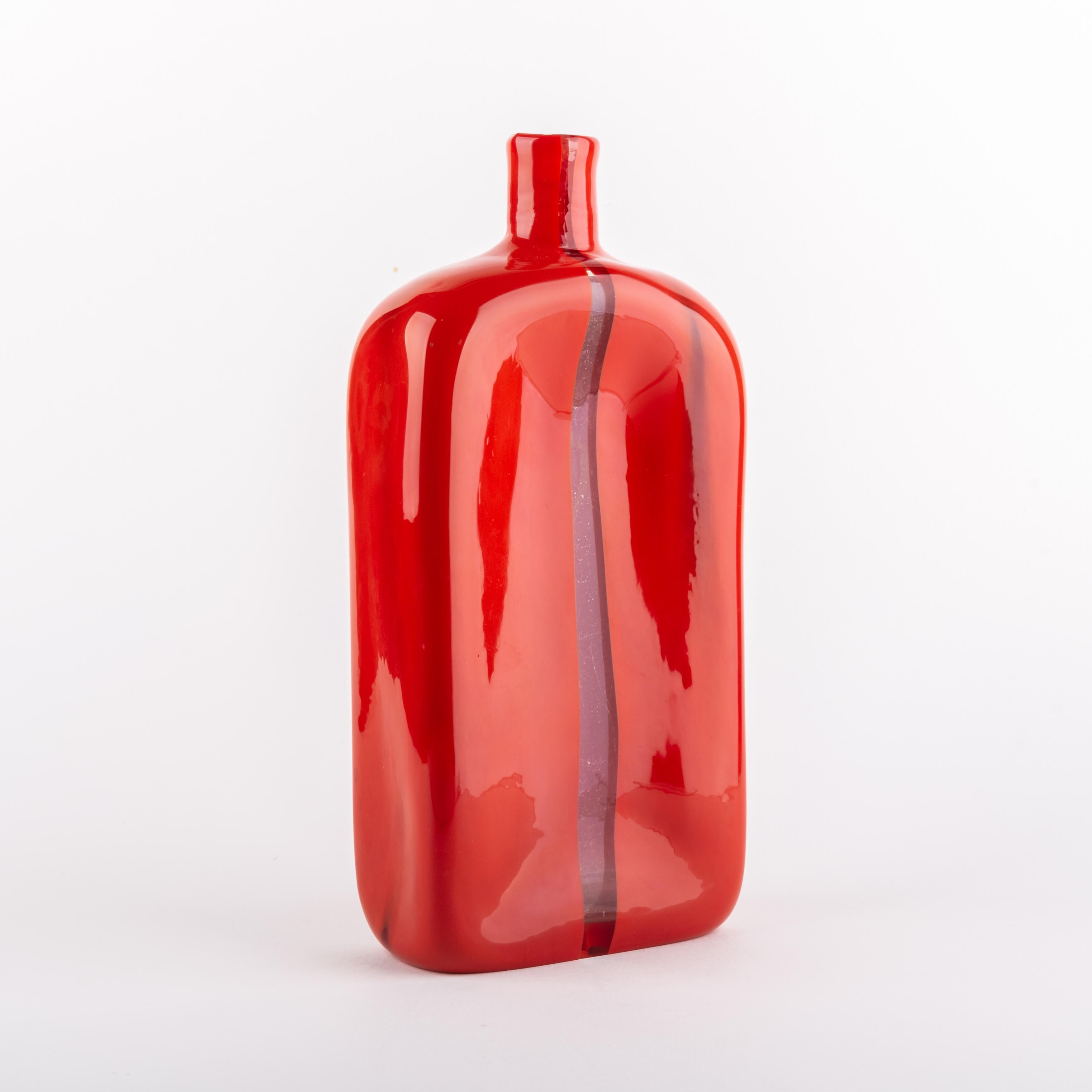 Sehr schöne und seltene rote Flasche:: entworfen von Toni Zuccheri und hergestellt von Venini Murano in Italien:: um 1960. 
Der Name dieser Serie ist Scolpito. Wenn man die Flasche ausstellt:: scheint sie in zwei Teile geteilt zu sein. 

Wir sind in
