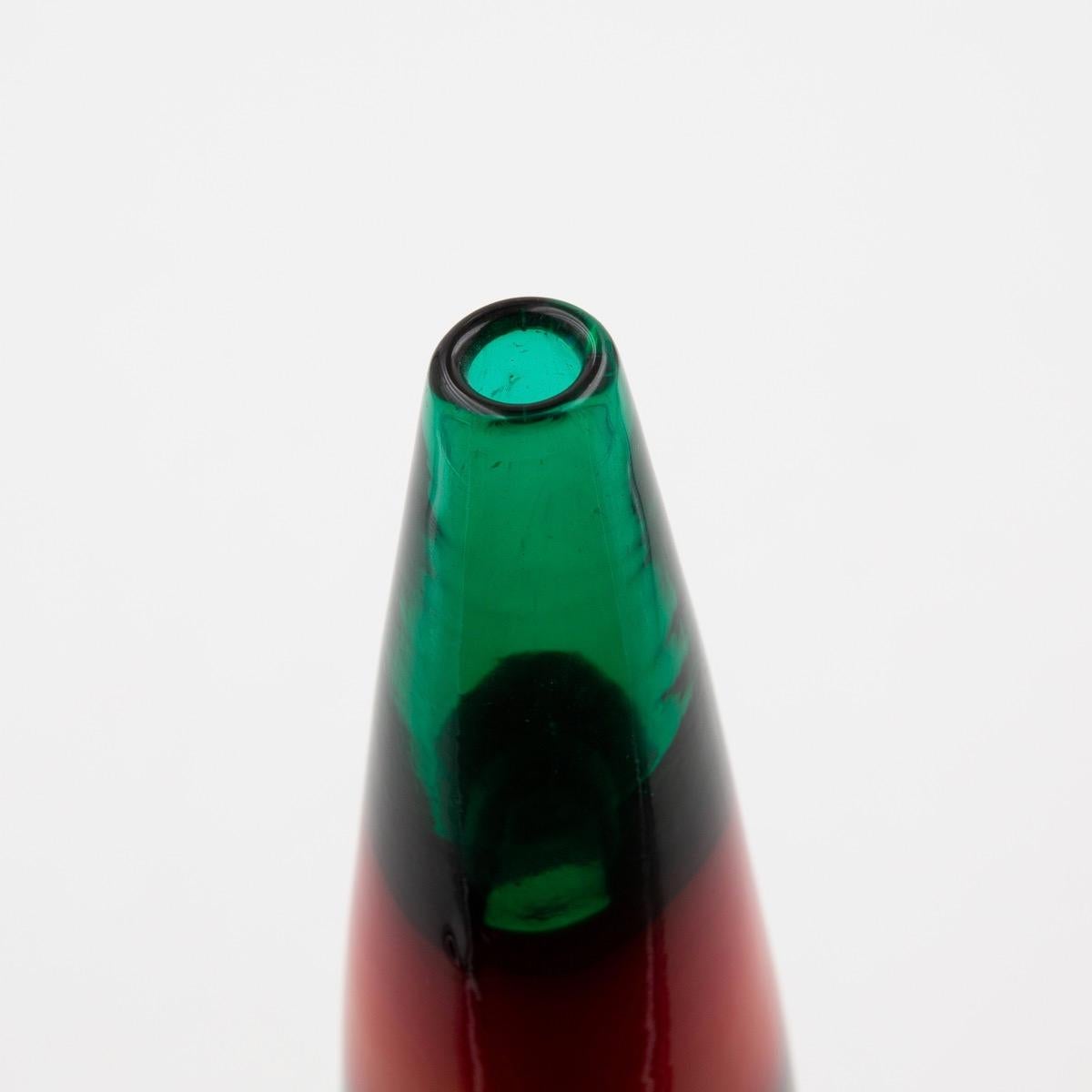 Vase with a cylindrical body and neck in the shape of a truncated cone in transparent green glass decorated with 3 horizontal bands in opaque glass.
Documented and known as model 4399.
Acid signed Venini Murano Italia
Designed and produced, circa