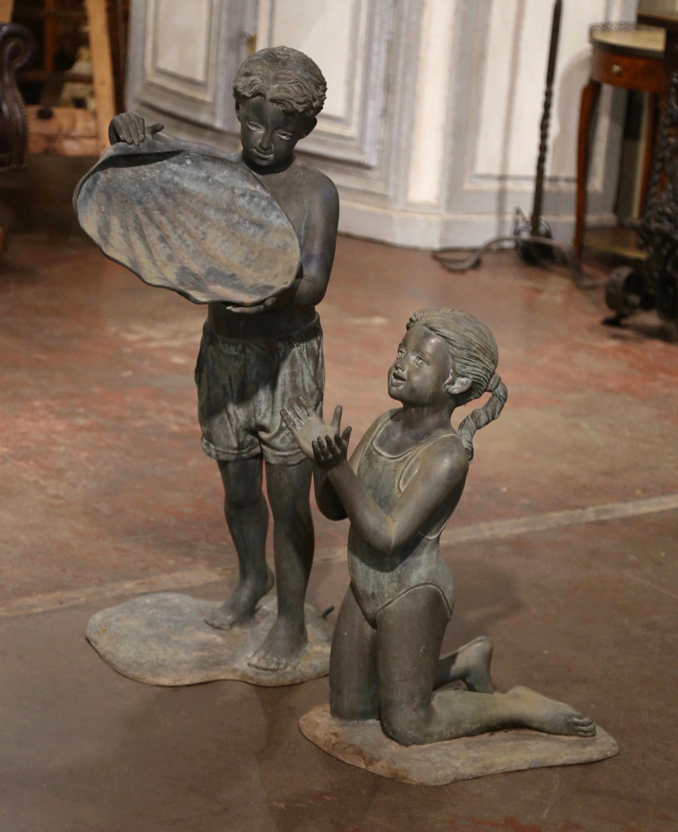 Dieser elegante Springbrunnen für den Außenbereich wurde um 1980 in Amerika hergestellt. Der aus Bronze gefertigte, zweiteilige Brunnen zeigt einen Jungen, der eine Muschel anhebt, um Wasser auf das Mädchen darunter zu gießen. Beide Figuren sind in
