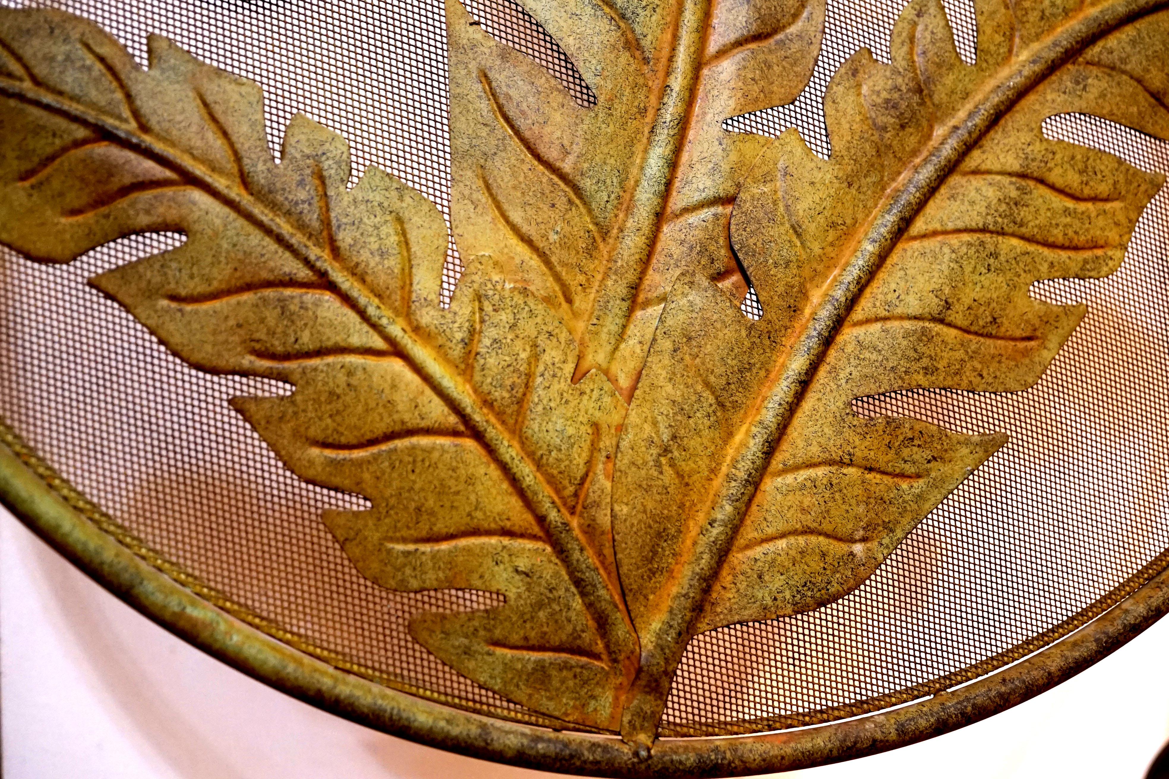 Winter is coming, and the light of a fire behind this screen will enhance any room. The round fireplace screen is decorative and functional with its verdigris wrought iron tone and palm leaf motif. It is Art Nouveau style wrought and cast iron