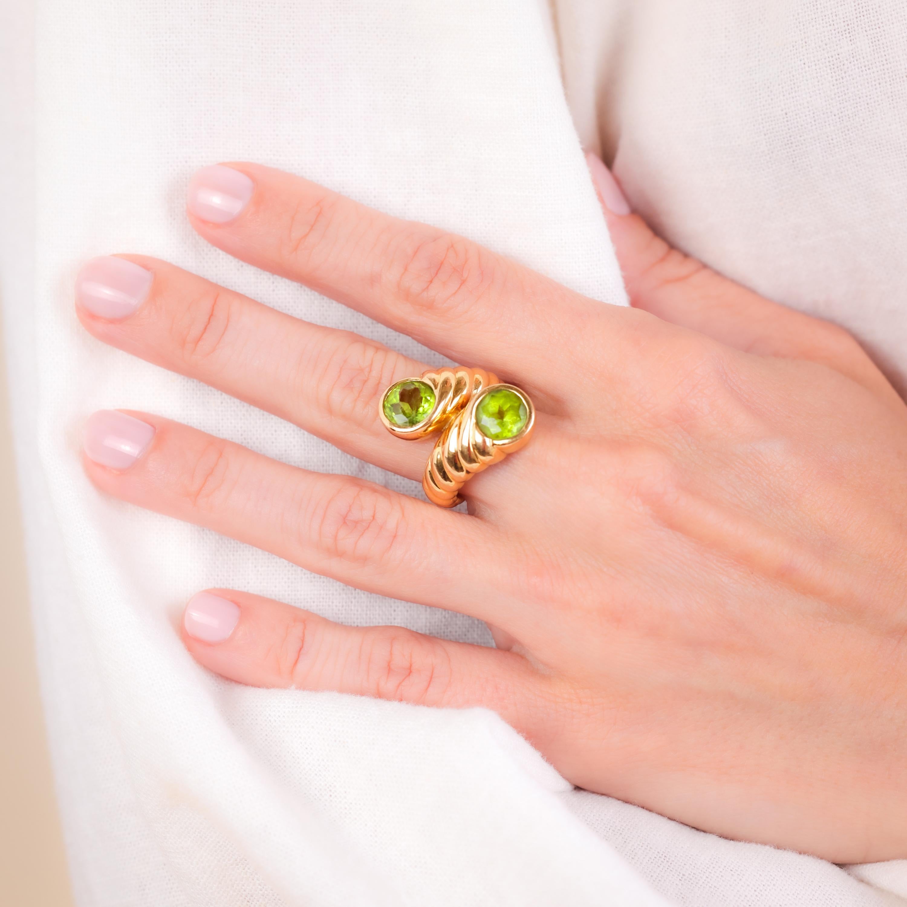 Marke: Verdura
Mittelstein: 2 Peridote
Schnitt: Rund
Gewicht: Ungefähr 3,5 Karat
Farbe: Grün
Metall: 18K Gelbgold
Epoche: Vintage By
Circa: 1980er Jahre
Punzierungen: Verdura, 750 und Feingehaltsstempel
Größe: 5 und kann in der Größe verändert