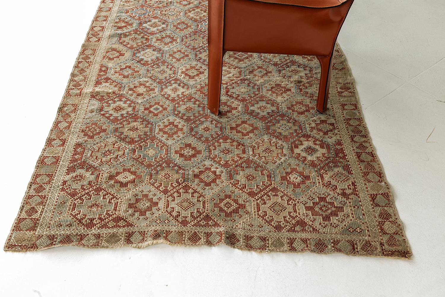 A timeless piece that is designed to captivate one’s stylish mind. Featuring this Vintage Verneh Flat Weave Kilim rug that displays repeated motifs of cruciform tiles with lozenge patterns inside in alternating colors of burnt orange, turquoise, sky