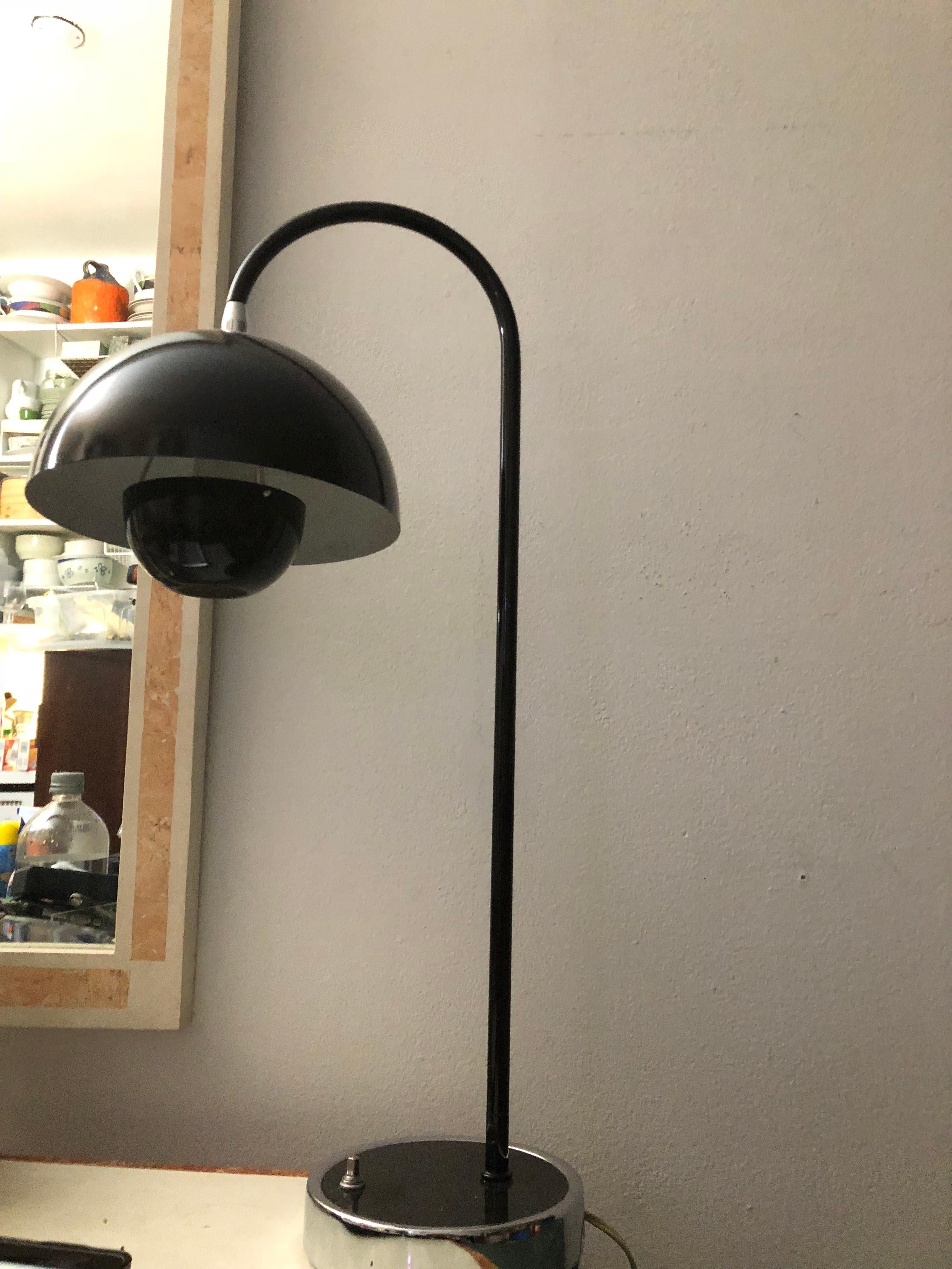 Gorgeous rarity, the first generation “Flower Pot” table lamp by Verner Panton. Articulating shade directs light, On/ Off button on base. Black enamel on steel - shade and cap. 

In 1968 the students' revolts in Paris, Rome and the United States