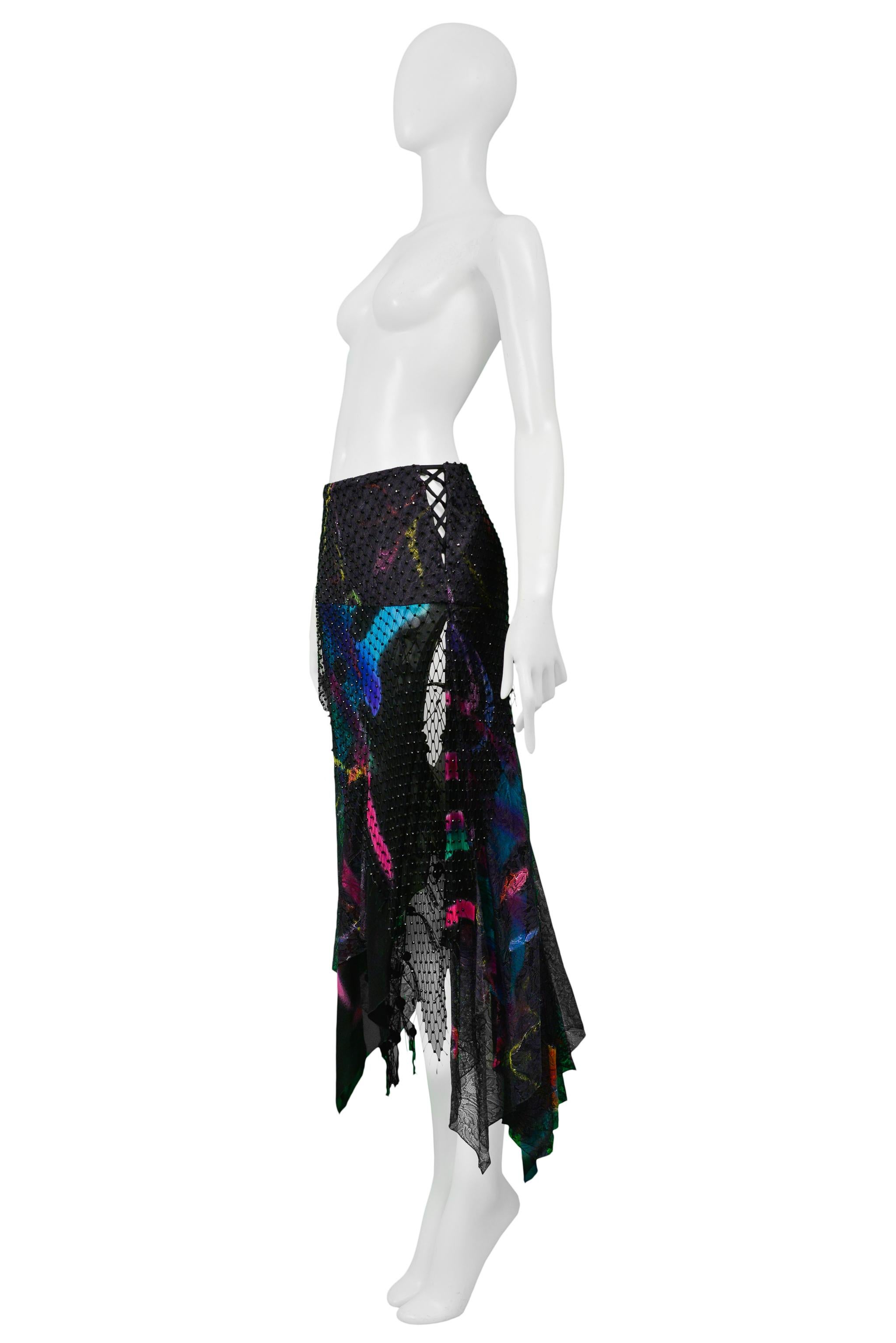 Resurrection Vintage is excited to offer a vintage Versace black silk evening skirt featuring lace and sheer inset panels, multicolor graffiti print, mesh overlay, large mesh and ball underskirt, exposed side lacing detail, slit, asymmetrical