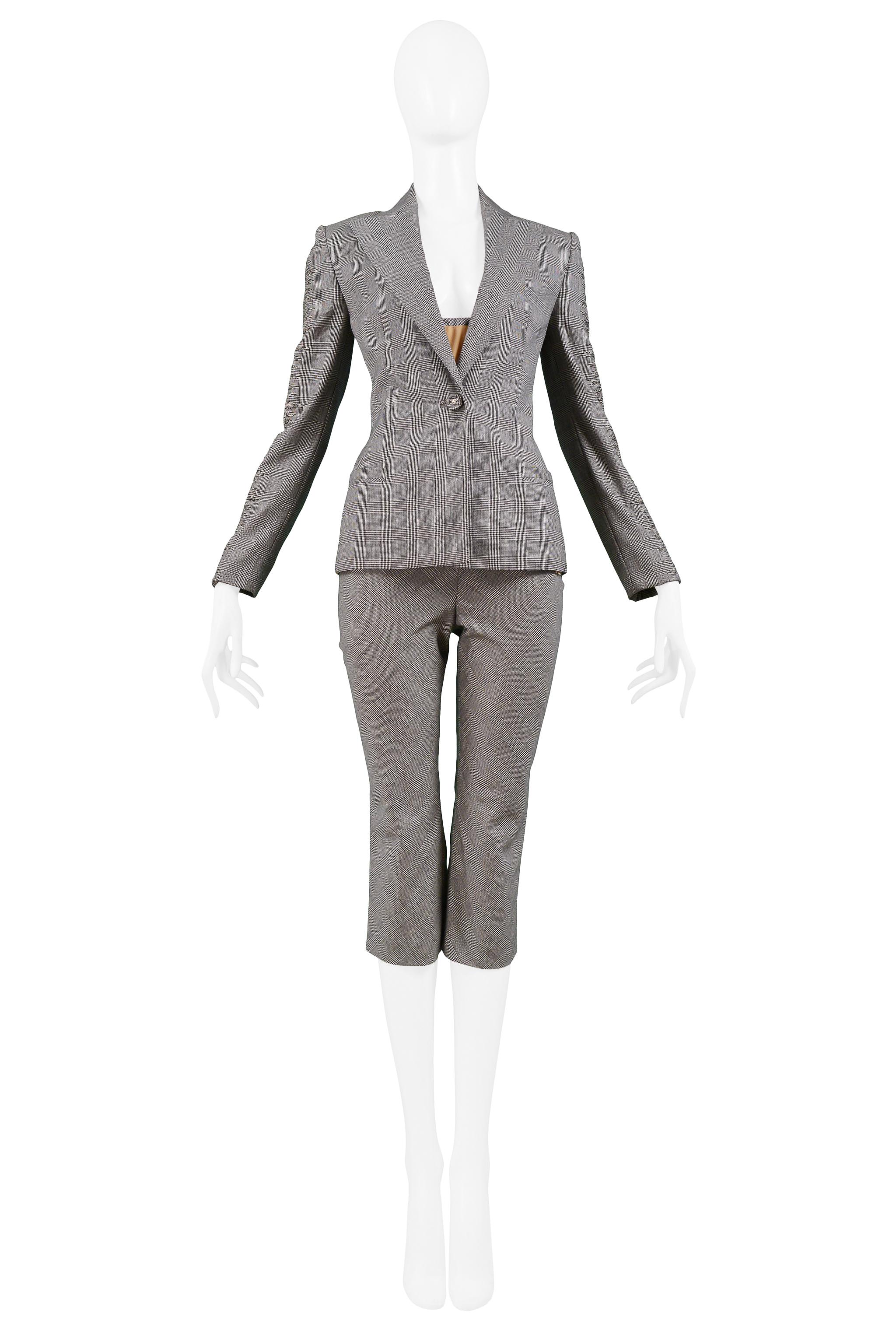 Vintage Versace couture grey wool windowpane check pantsuit. The jacket features embroidered details on sleeves and single button closure with self-faced button. The pants feature a cropped length and side closure. The suit also features two tops, a