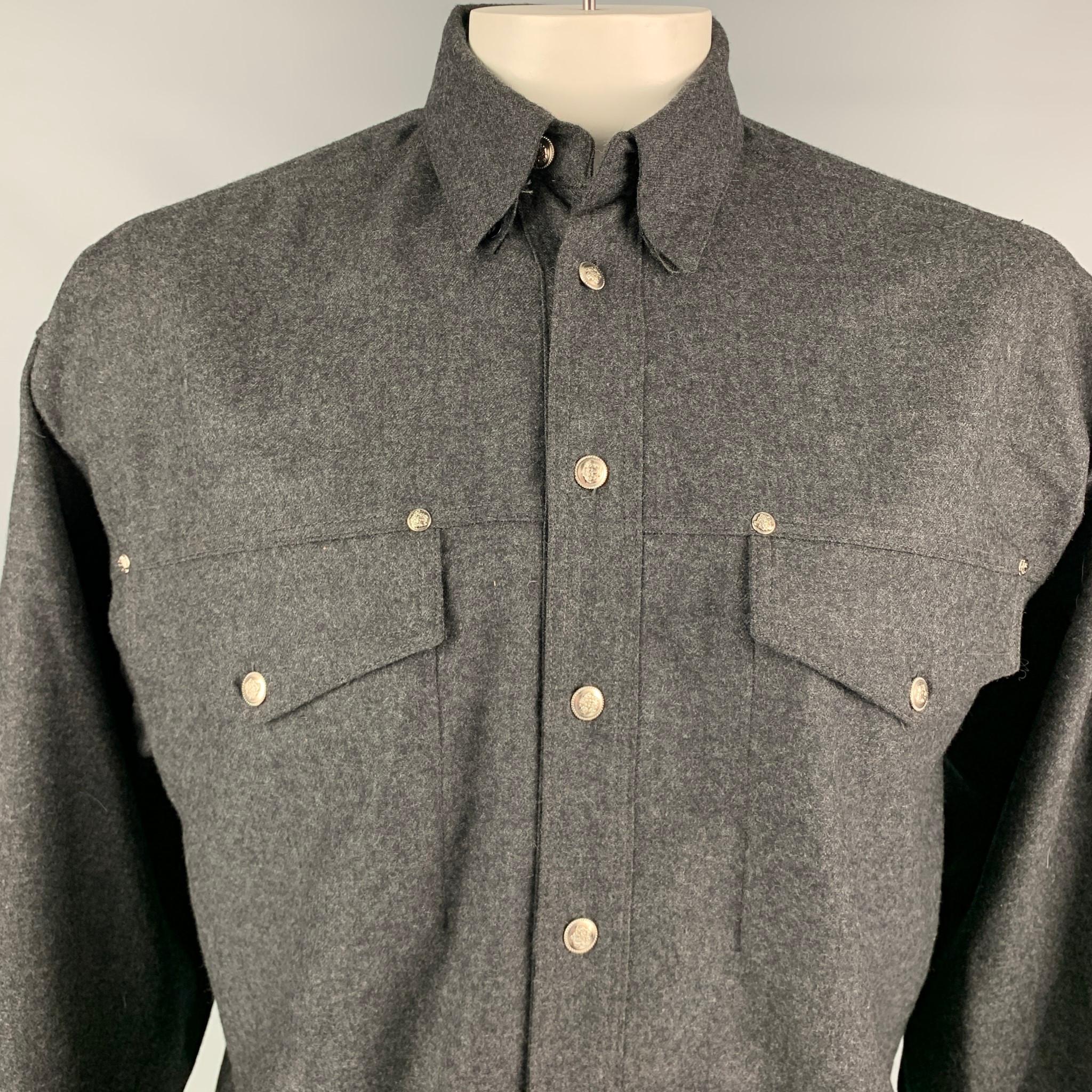 Vintage VERSACE JEANS COUTURE long sleeve shirt comes in a charcoal wool featuring a button down style, patch pockets, and a silver tone medusa head buttoned closure. 

Very Good Pre-Owned Condition.
Marked: L

Measurements:

Shoulder: 24 in.
Chest: