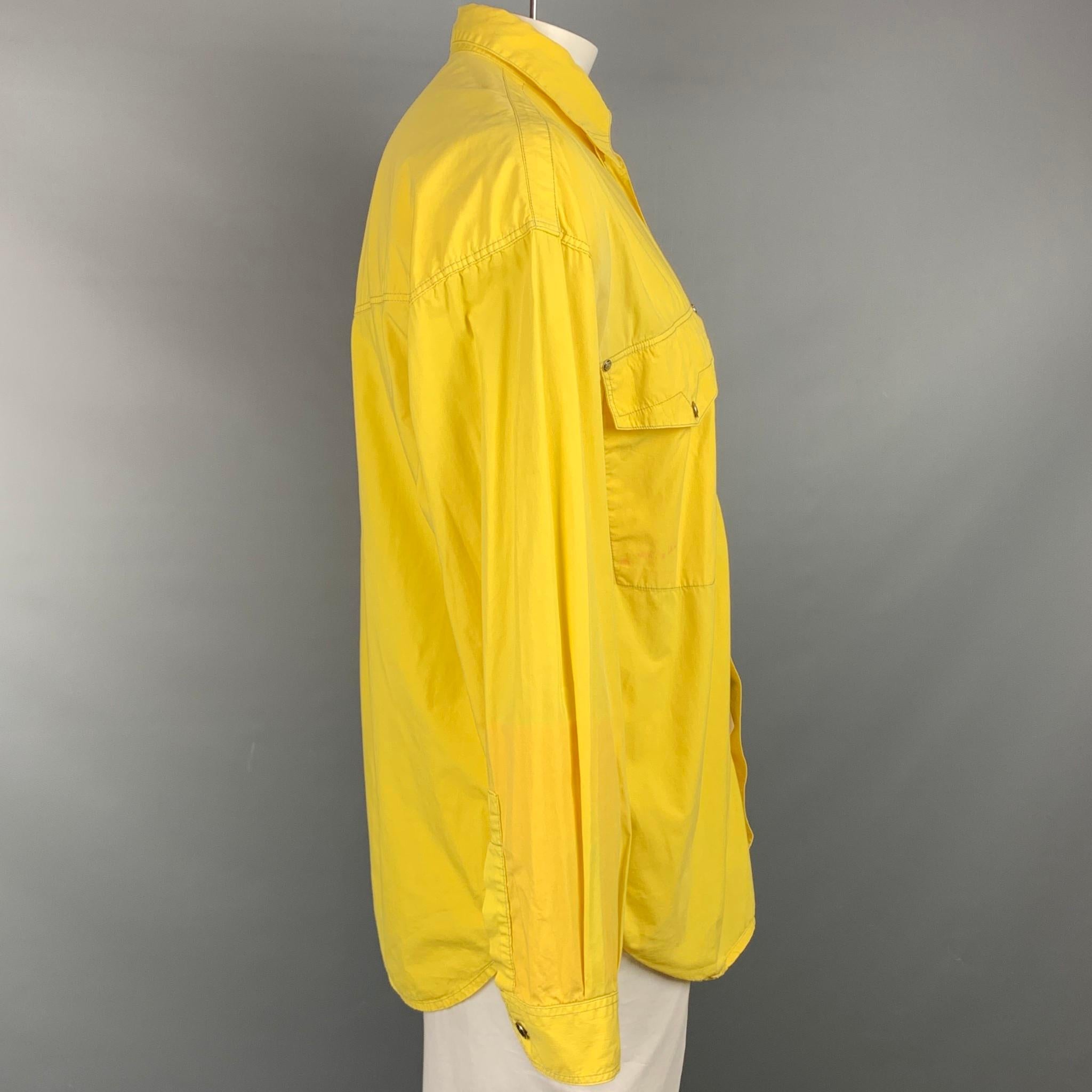 Vintage VERSACE JEANS COUTURE Langarmhemd aus gelber Baumwolle mit Kontrastnähten, Knopfleiste, lockerem Schnitt, aufgesetzten Taschen und silberfarbenen Medusa-Kopfknöpfen. Hergestellt in Italien.

Guter Pre-Owned Zustand. Leichte Verfärbungen an