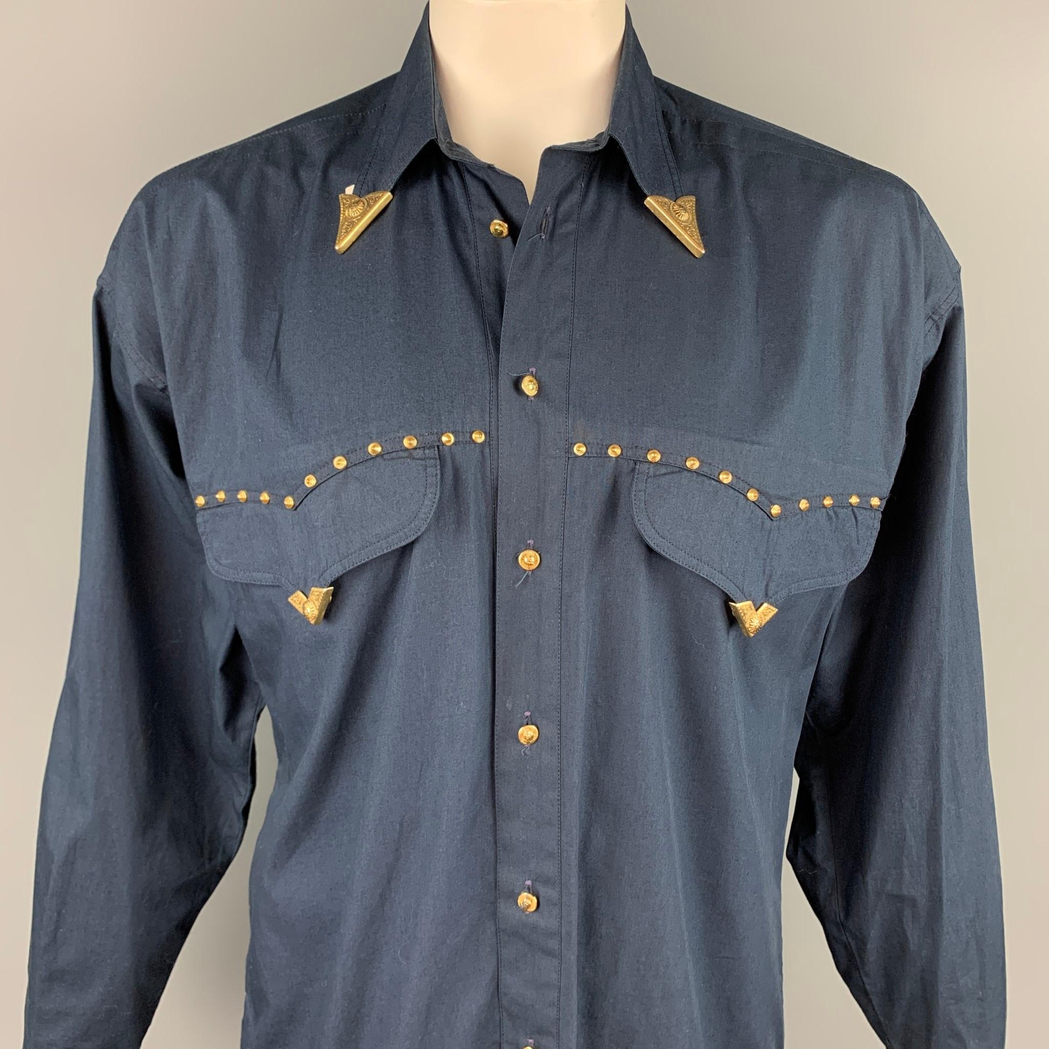 Vintage VERSACE JEANS COUTURE long sleeve shirt comes in a navy cotton with gold tone hardware details featuring a cowboy button up style, oversized, front pockets, and a pointed collar. Made in Italy.

Good Pre-Owned Condition.
Marked: