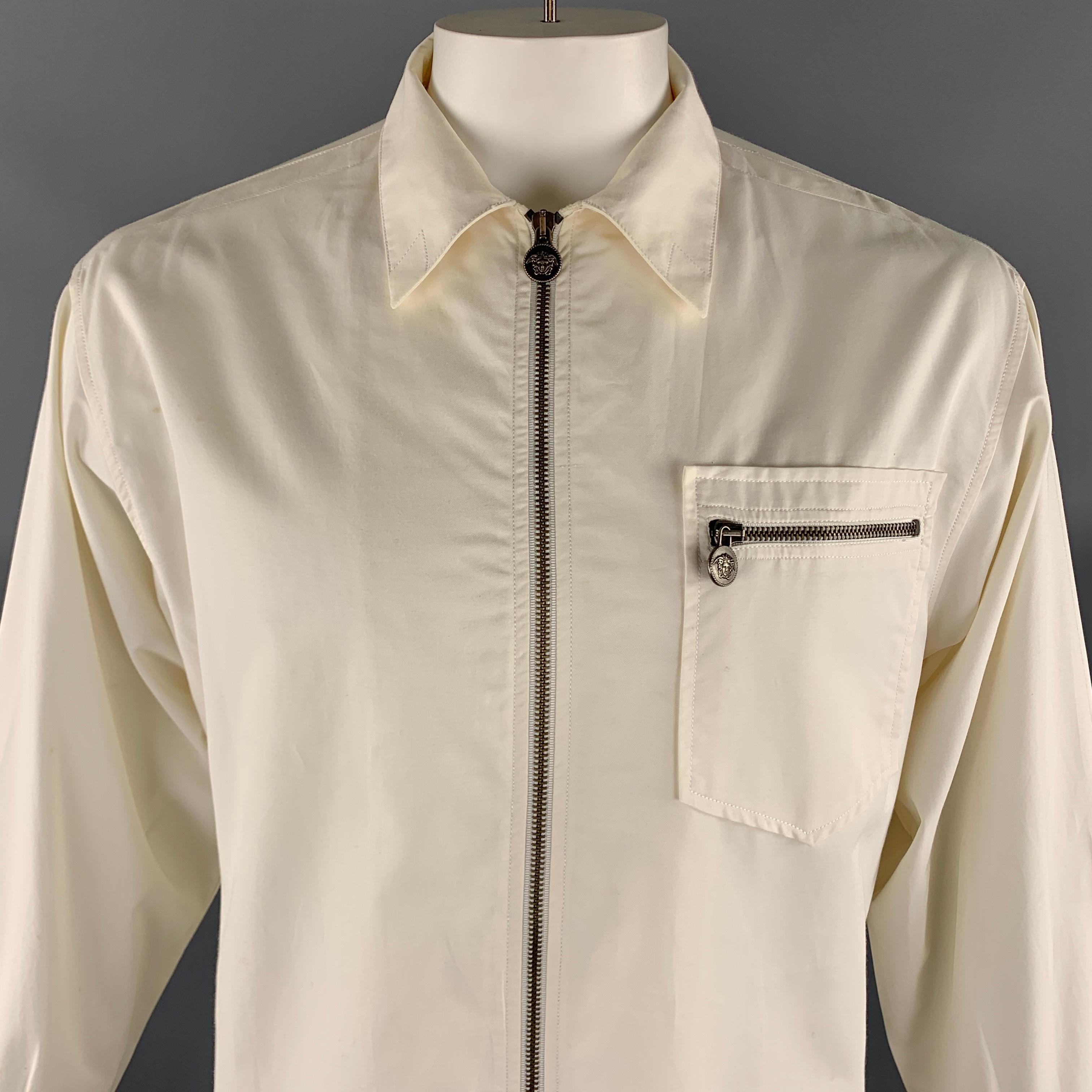 Vintage VERSACE JEANS COUTURE shirt jacket comes in a solid off white cotton material, with a patch pocket, silver tone metal embossed buttons, medusa head embellishments, buttoned cuffs, zip up. As is. Made in Italy. 

Very Good Pre-Owned