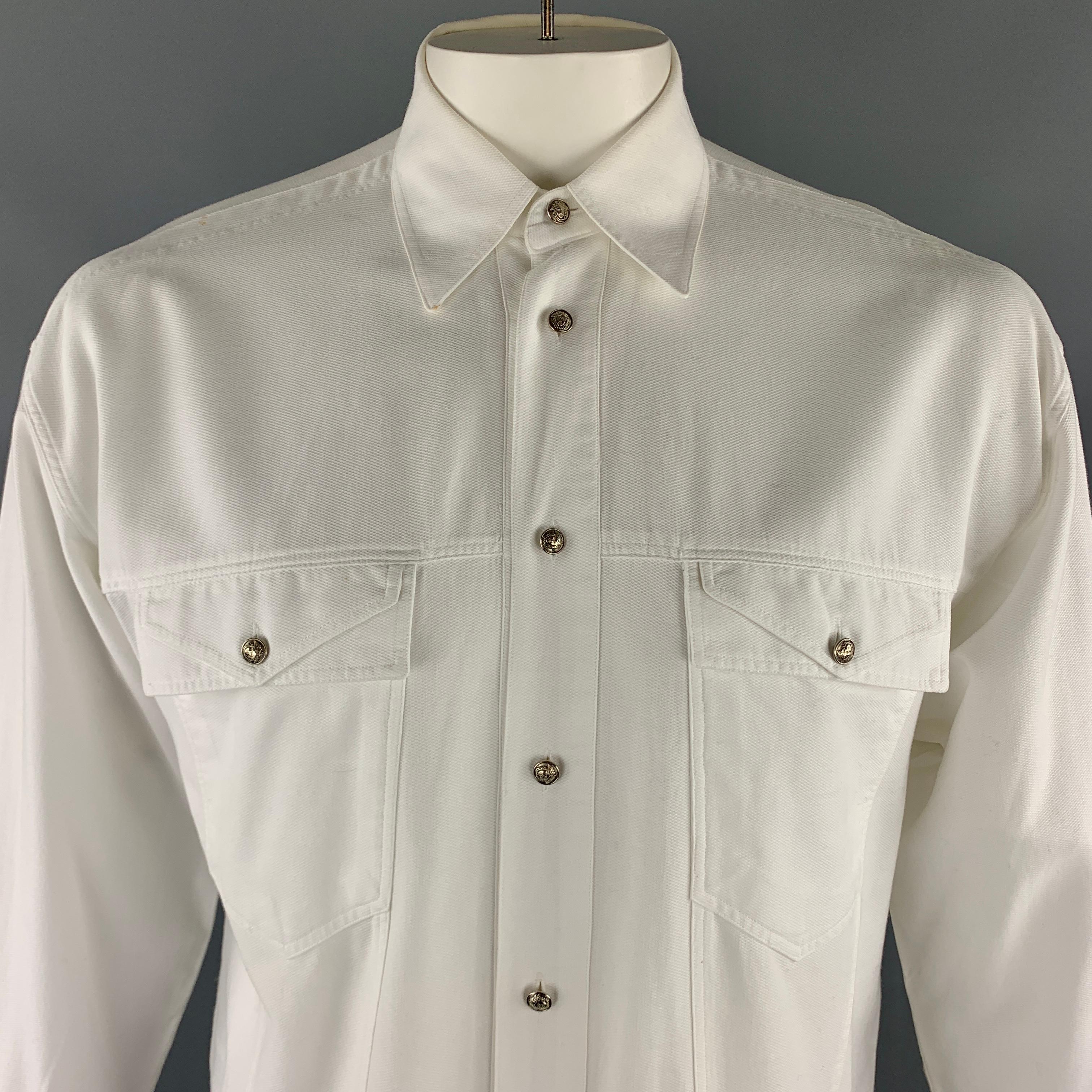 Vintage VERSACE JEANS COUTURE jacket comes in a solid white cotton material, featuring a buttoned front, patch pockets, buttoned cuffs, and silver tone metal medusa embossed buttons, button up. As is. Made in Italy. 

Very Good Pre-Owned