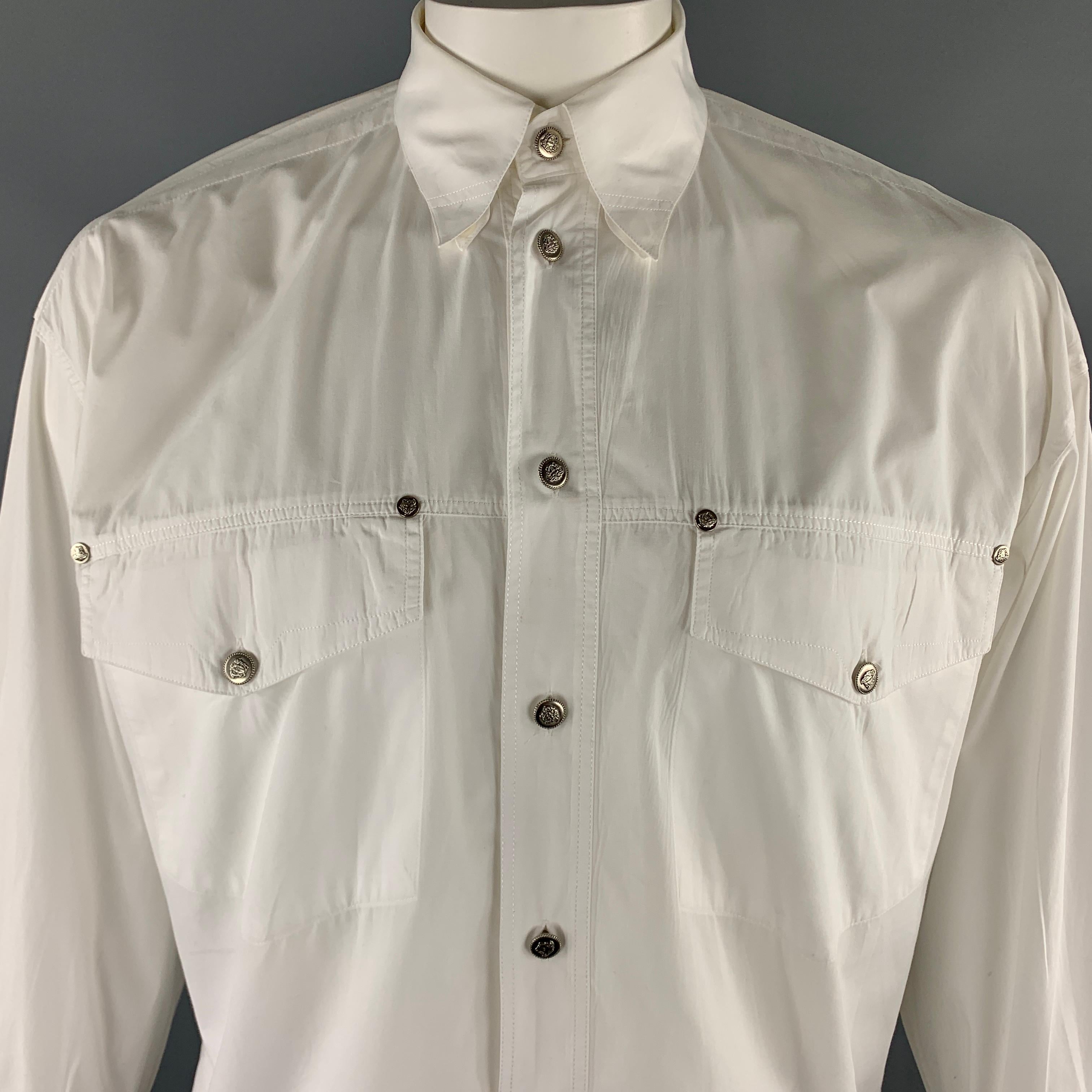 Vintage VERSACE JEANS COUTURE jacket comes in a solid white cotton material, featuring a buttoned front, patch pockets, buttoned cuffs, and silver tone metal medusa embossed buttons. As is. Made in Italy.  

Very Good Pre-Owned Condition.
Marked:
