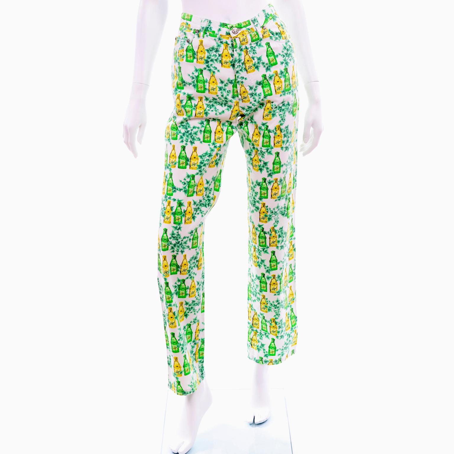 This pair of vintage Versace Jeans Couture pants is in a white, green and yellow 100% Cotton print that has ivy vines and bottles of Versace Yellow Jeans perfume. These 1990's jeans have the silver medusa hardware and close with a front zipper and