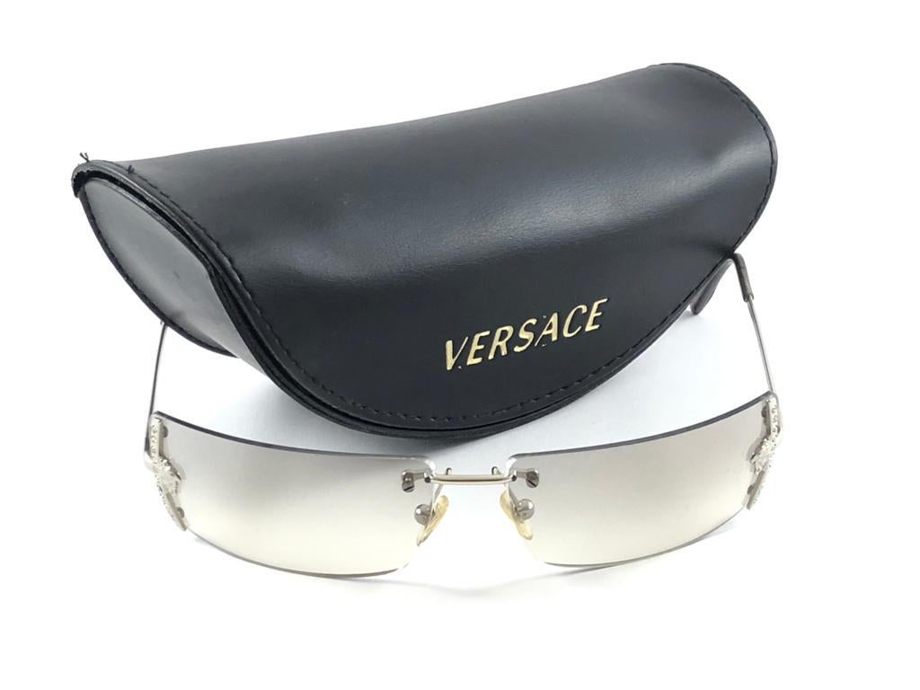 Vintage Gianni Versace Silver Rimless Frame Sunglasses Holding pair of Light Grey lenses.
New, Never worn.
It May Show So Minor Sign Of Wear Due To more Than 20 Years Of Storage.
Made in italy.


Front.                            14 cms
Lens Hight  