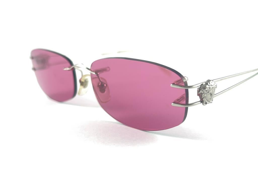 Vintage Gianni Versace rimless Frame Sunglasses Holding pair of candy pink lenses.
New, Never worn.
It May Show So Minor Sign Of Wear Due To more Than 20 Years Of Storage.
Made in italy.


Front.                        13 cms
Lens Hight             