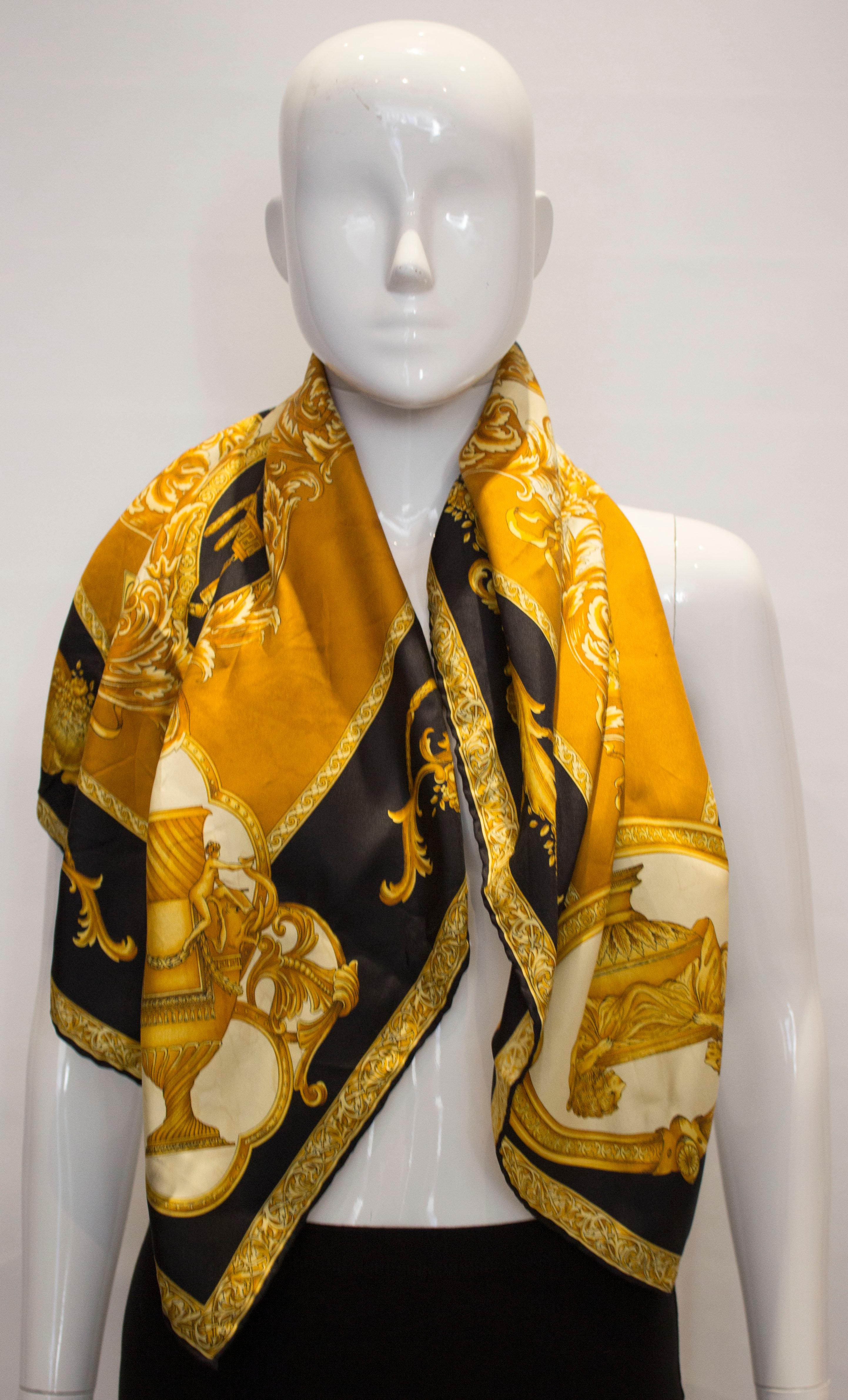A stunning vintage silk scarf by Versace. The scarf has hand rolled edges and is in a gold, black and ivory design.