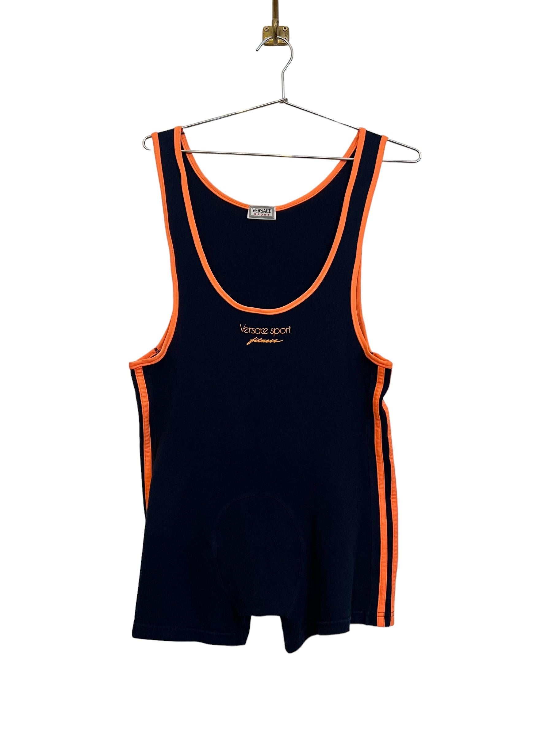 Iconic early 1990's Vintage VERSACE Sport 'Fitness' Sport suit in navy blue with contrasting orange racer striped sides, piping and logo printed details.

Features: 
Deep Muscle fit Scoop Neck
striped sides
Stretchy Material
MADE IN ITALY

Size