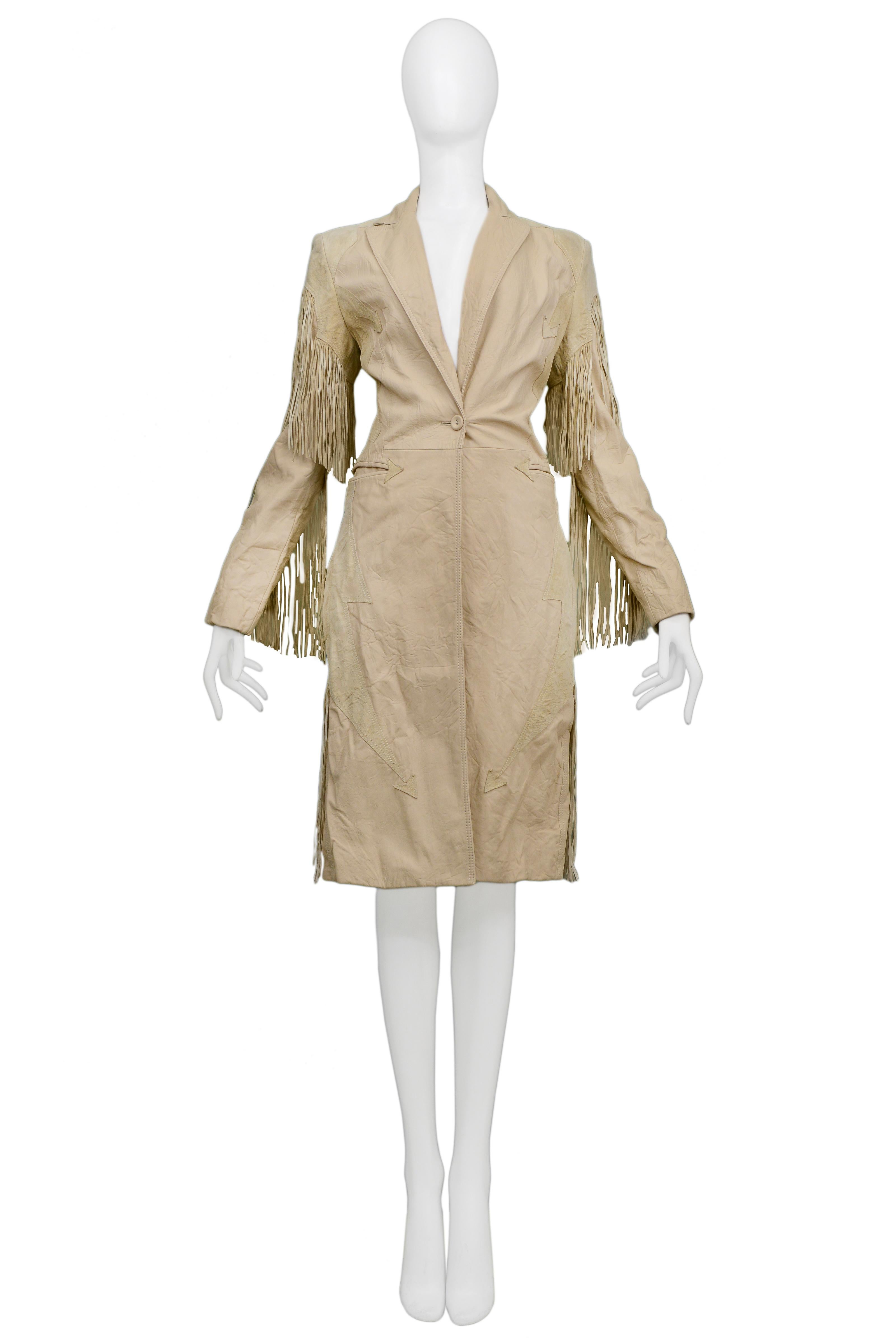 We are excited to offer a vintage Versace western-inspired tan leather coat featuring tailored notch collar and slim lapels, heavy fringe, arrow appliques, elbow insets, one-button closure, slit pockets with arrow insets, button cuffs, and back