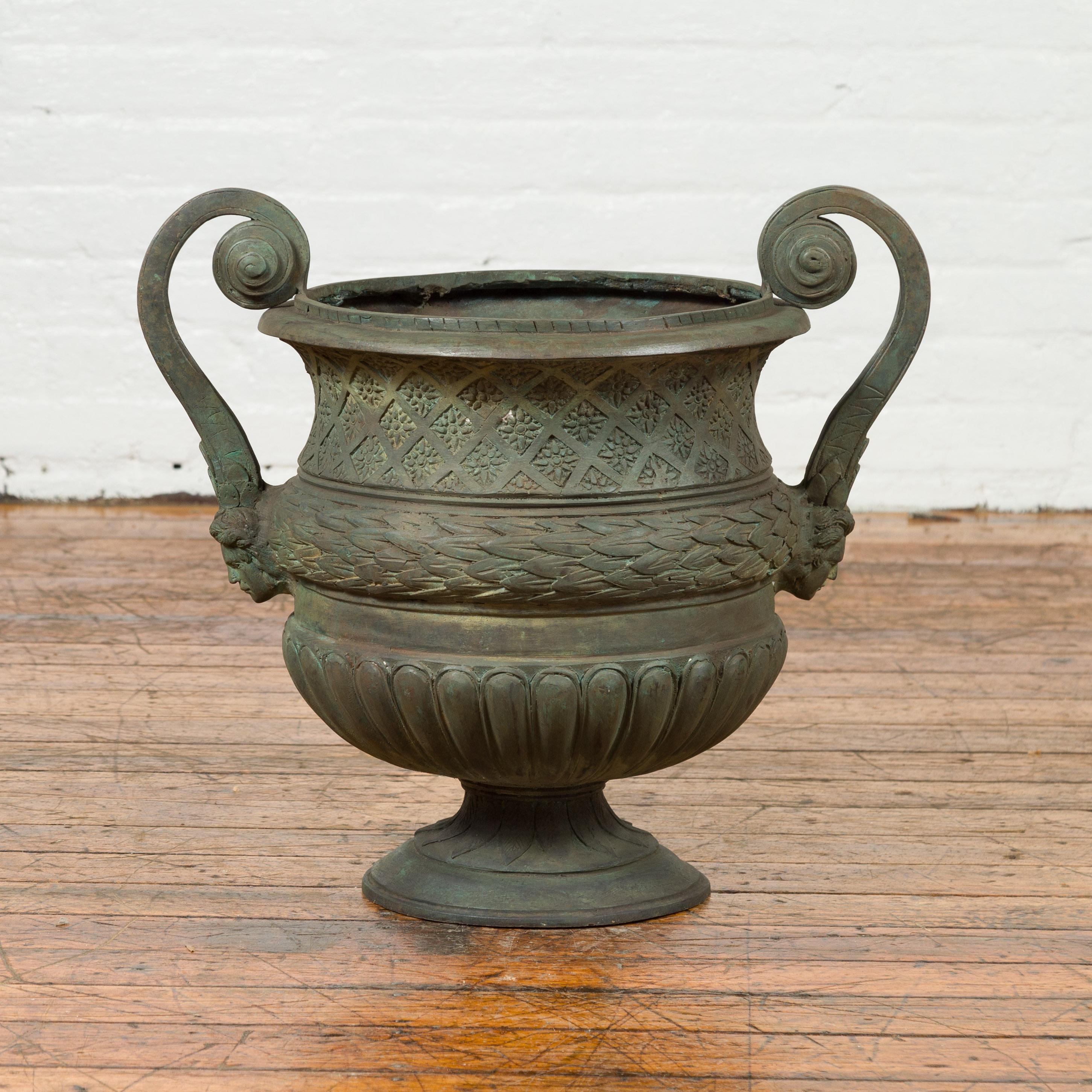 A vintage Versailles style bronze urn planter from the mid-20th century, with scrolling handles and verde patina. Created with the traditional technique of the lost-wax (à la cire perdue) that allows a great precision and finesse in the details,