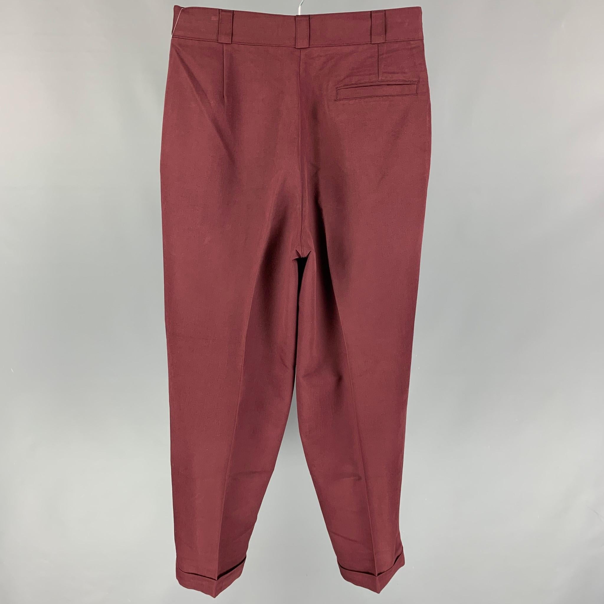 Vintage VERSUS by GIANNI VERSACE pants comes in a burgundy pleated material featuring a pleated style, high waisted, cuffed leg, and a zip fly closure. Made in Italy. 

Very Good Pre-Owned Condition.
Marked: 32/46

Measurements:

Waist: 30 in.
Rise: