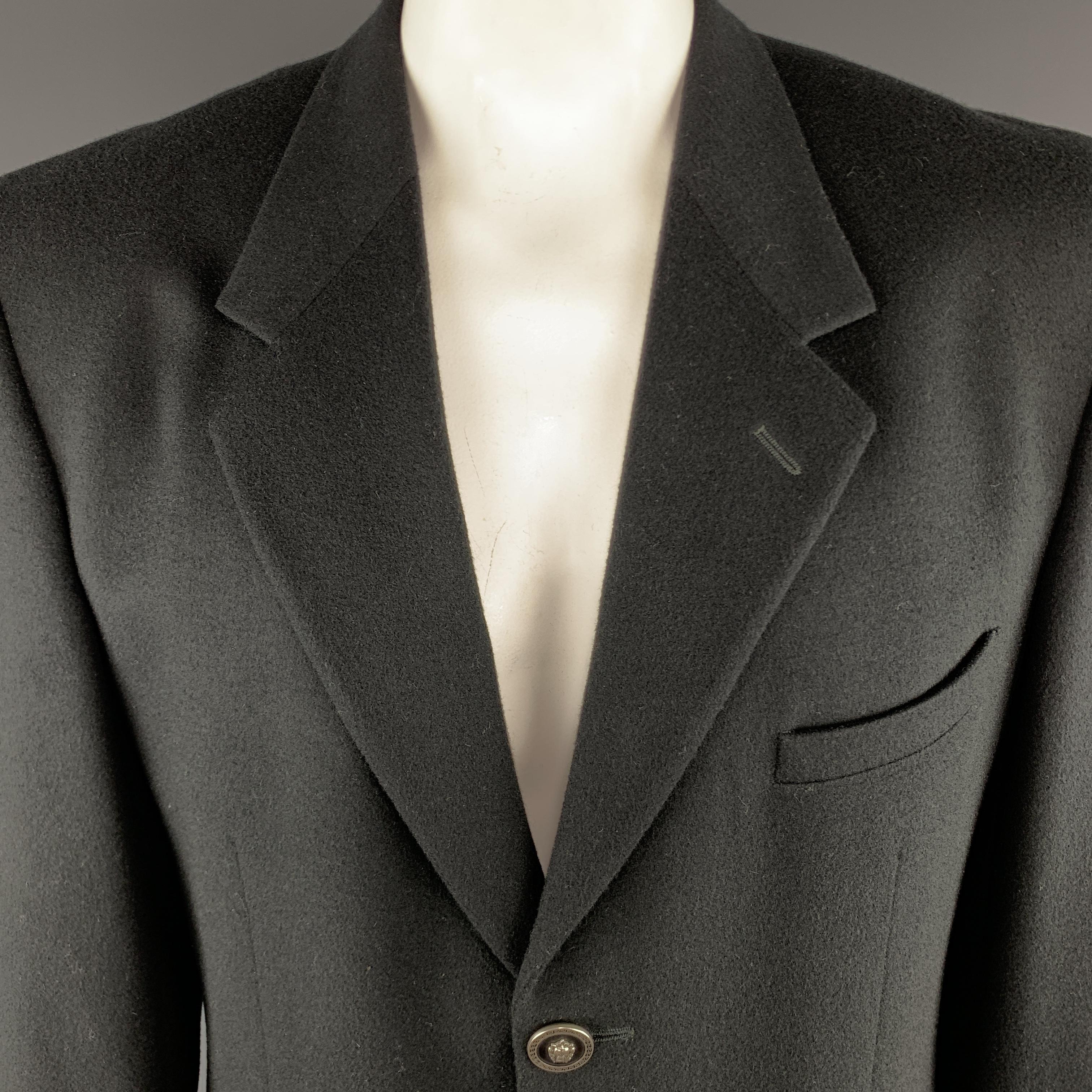 Vintage VERSUS by GIANNI VERSACE Sport Coat comes in a black tone in a solid wool / cashmere material, with a notch lapel, embossed buttons, slit pockets, three buttons at closure, single breasted, and buttoned cuffs. Made in Italy. 

Excellent