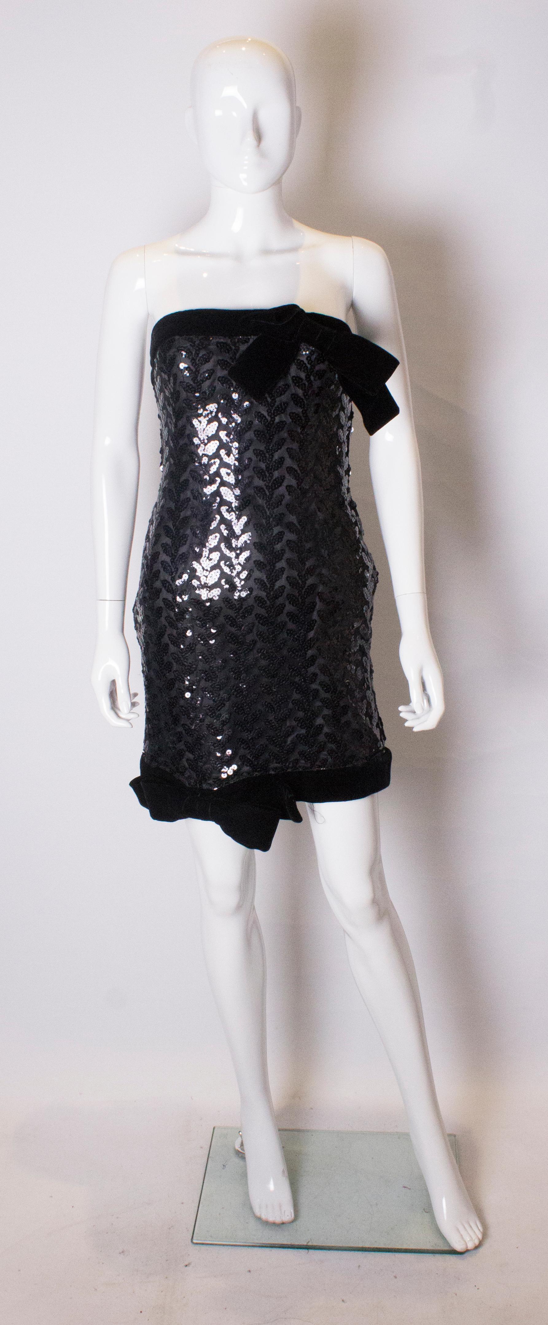 A chic cocktail dress by Victor Costa . The dress is strapless with the body of the dress covered in sequins with a velvet band at the top and hem. Labelled style 8160 F.
Measurements Bust 34'', length 28'' shoulder to hem aprox 36''