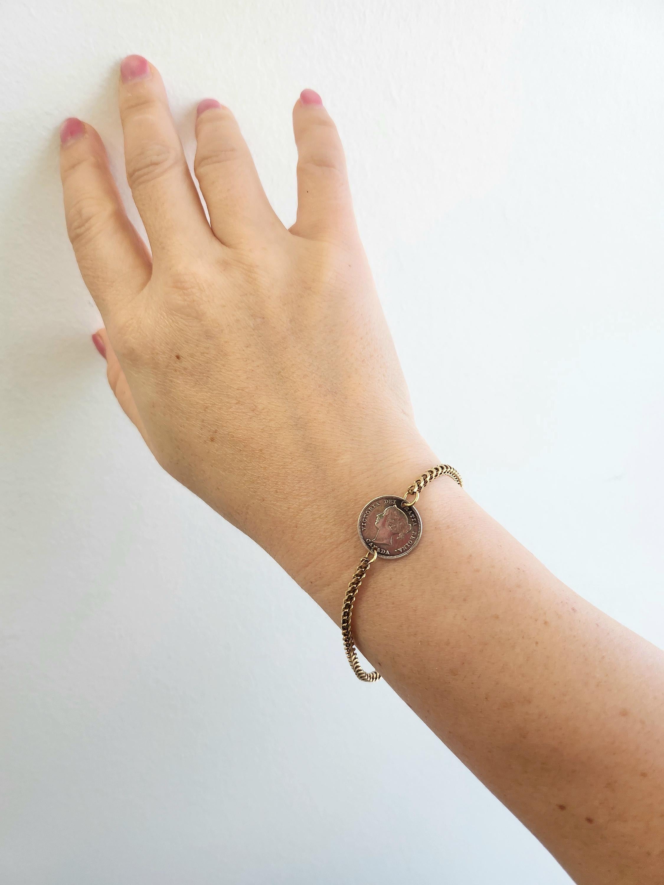 This delightful vintage bracelet features an antique Canadian coin set in a classic 9K gold Franco chain. The obverse side of the coin reads “VICTORIA DEI GRATIA REGINA. CANADA”, showcasing a regal portrait of Queen Victoria. The reverse side bears
